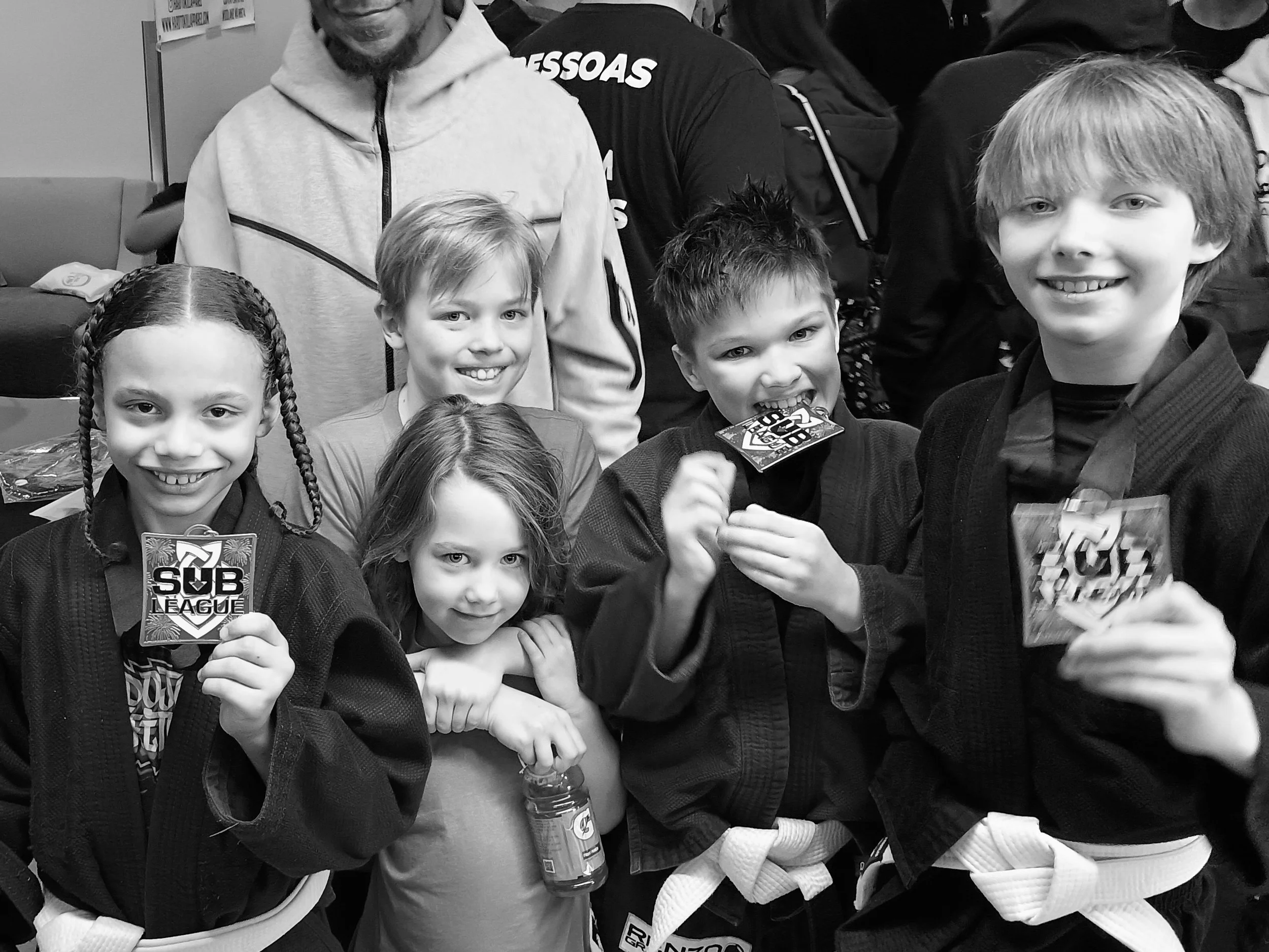 Kids jiu jitsu team members celebrating their fellow competitors' wins at the Sub League Open tournament