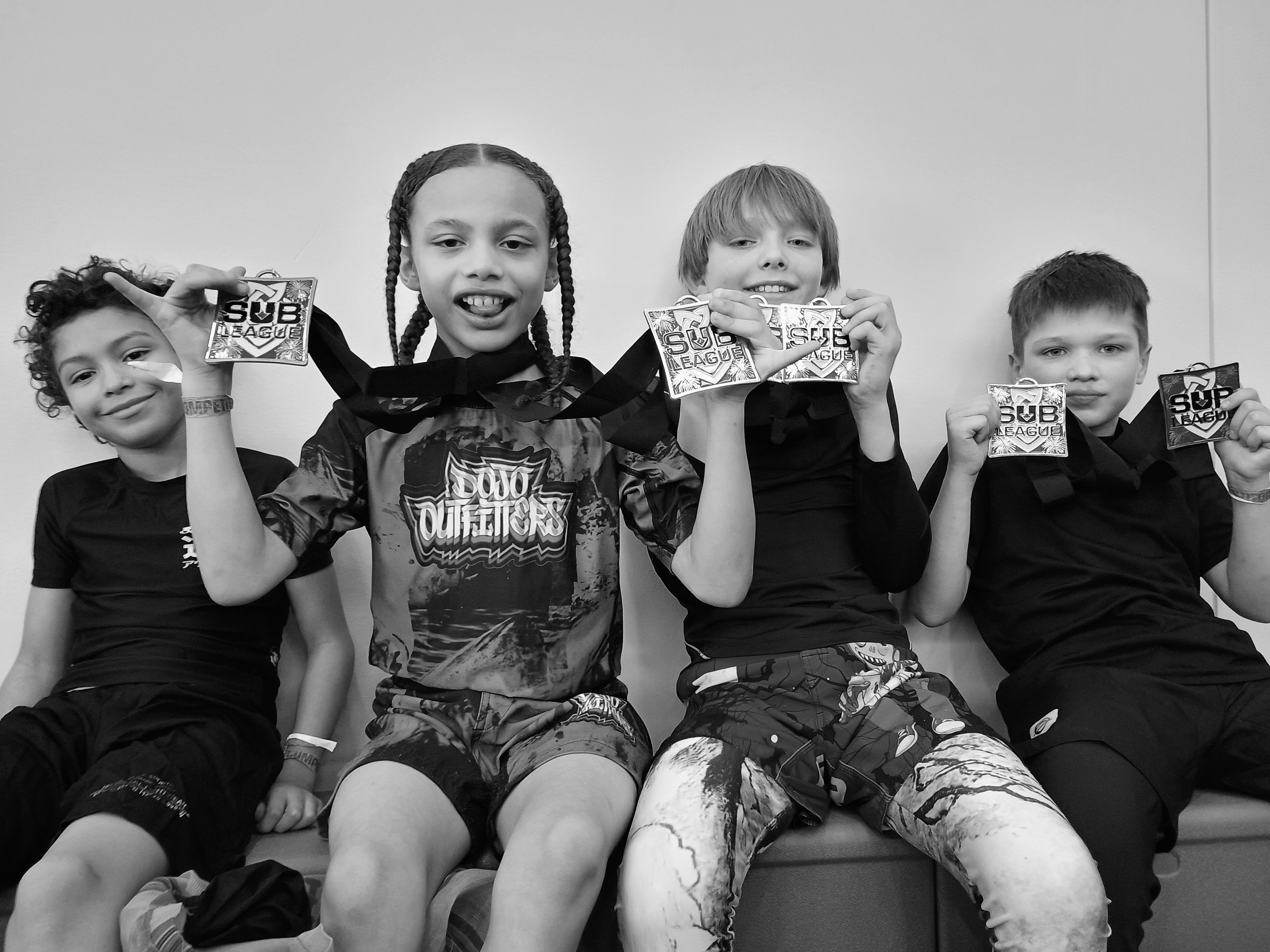 Oregon Grappling Arts kids Brazilian Jiu Jitsu team members showing their medals off at a competition