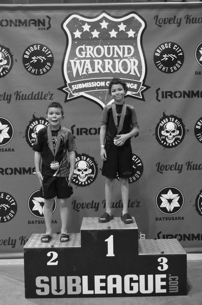 Youth competitor standing atop podium after placing first at the GRound Warrior tournament in Salem, OR