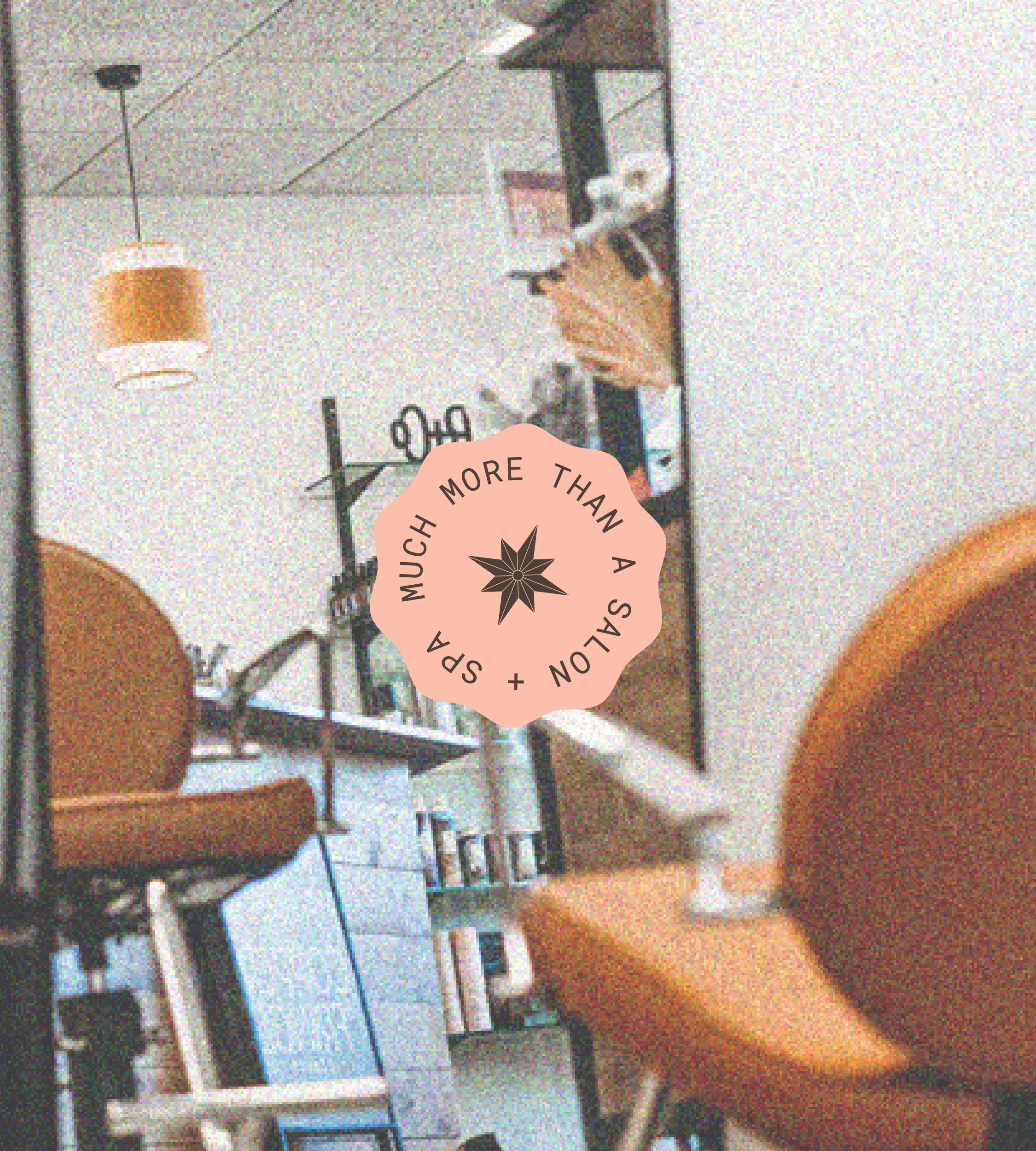 Interior of a cafe with two orange chairs, a side table with a coffee cup and glasses, a shelf with books, and a coffee machine. There is a pendant light hanging from the ceiling, and a filter sticker reads "More than a salton + share much."