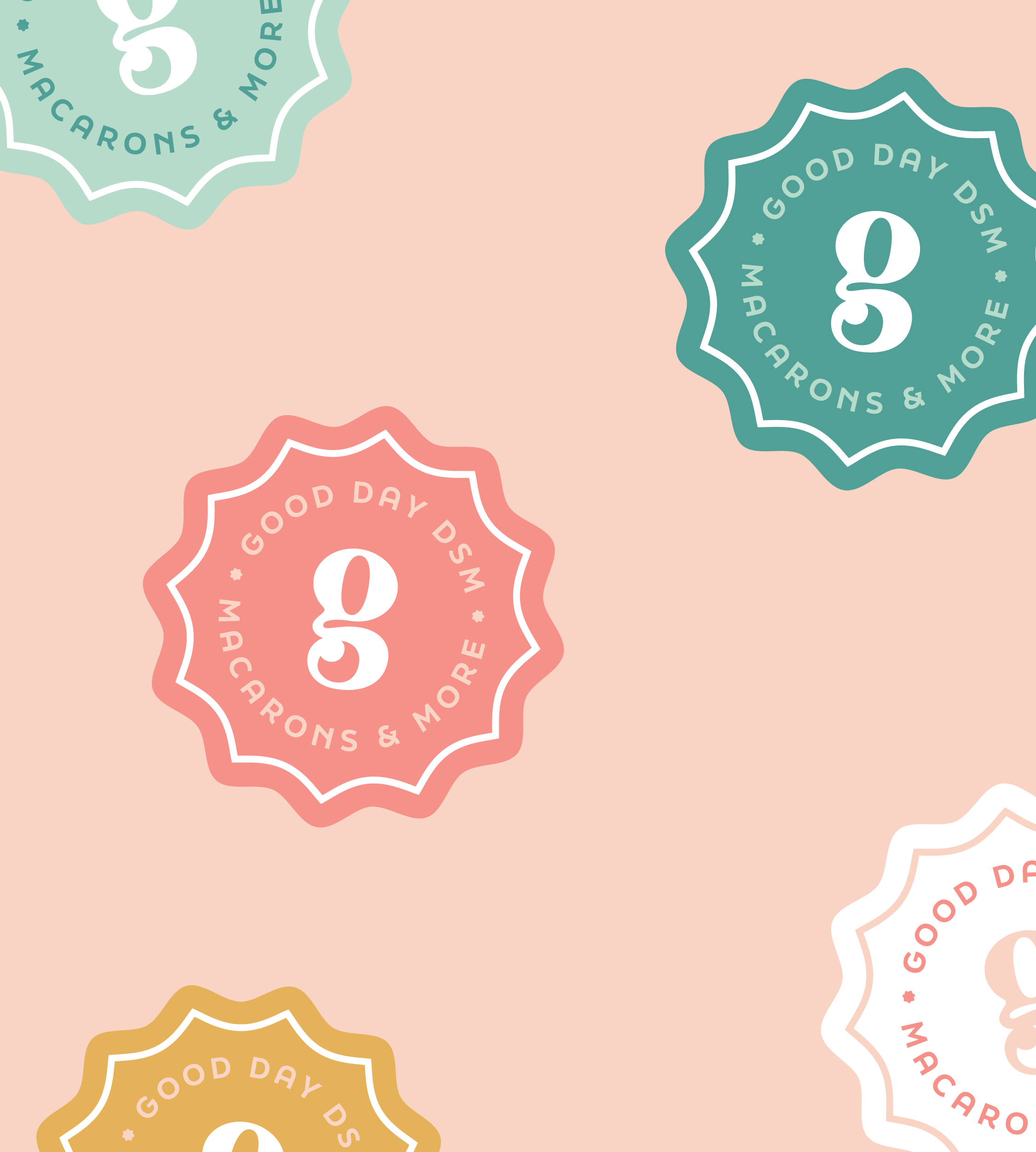 Colorful seal designs on a pink background with phrases 'Good Day DSM,' 'Macarons & More,' and a stylized number 8 in the center.