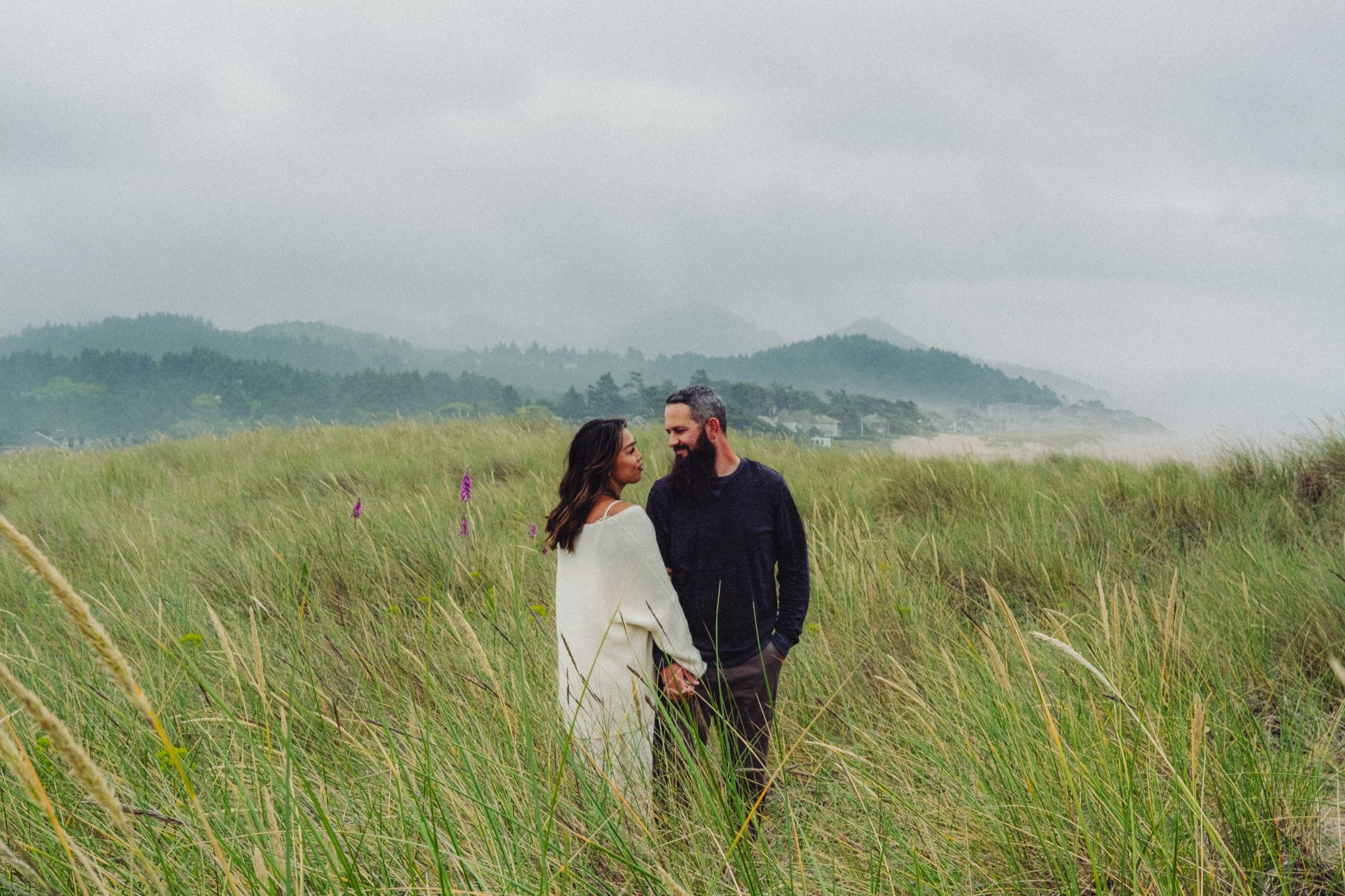 moody couple portrait in sand dunes of oregon coast