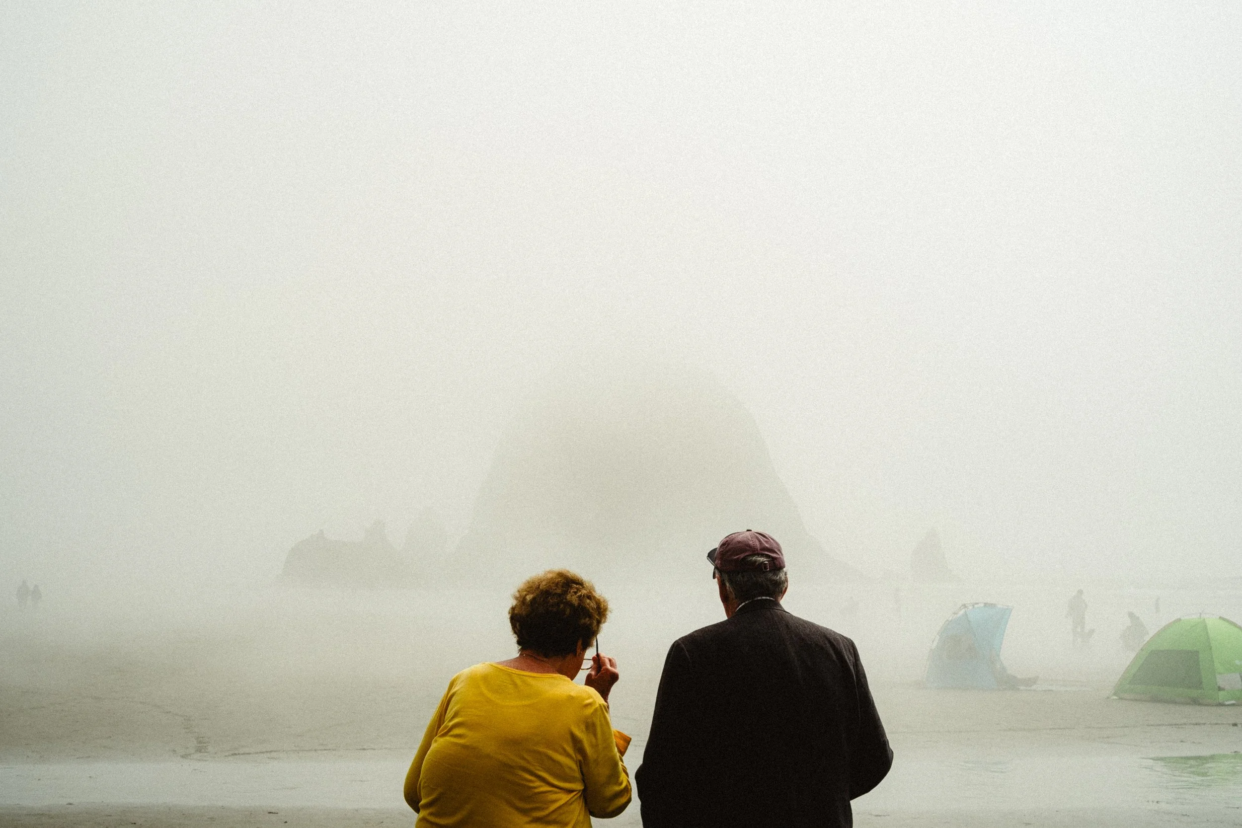 nostalgic image of elderly couple on cannonbeach looking at haystack rock