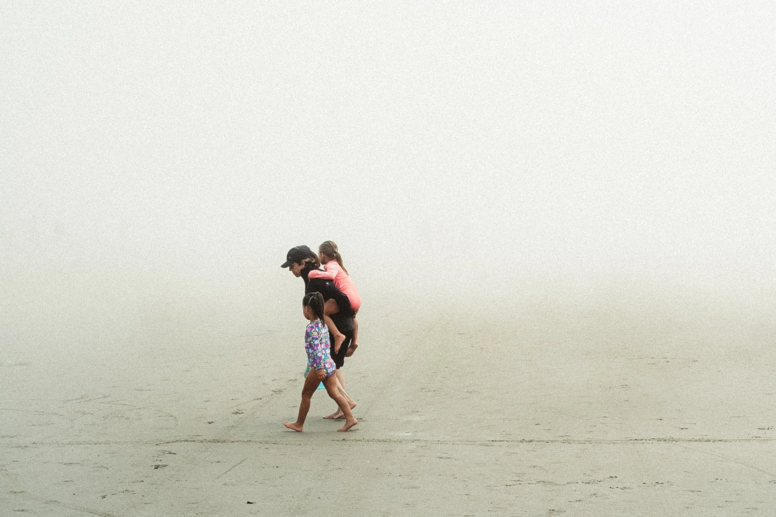 candid of family walking on the beach when cannon beach is covered in fog