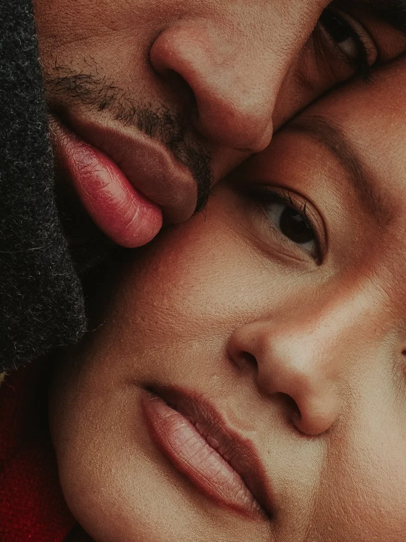Close-up of a man and woman sharing an intimate moment with their faces close together, focusing on their eyes, nose, and lips.