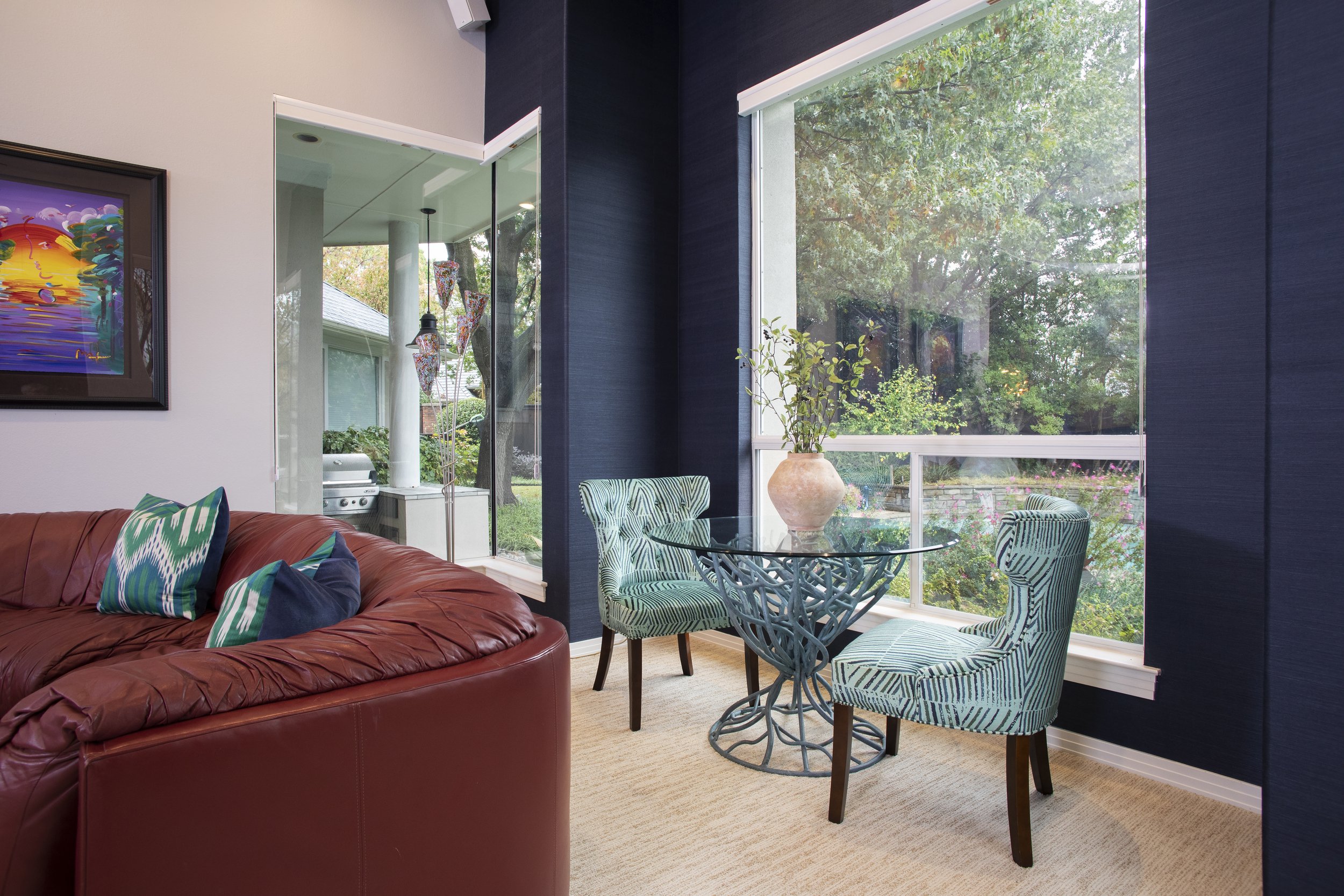 Sitting area with a glass table and striped turquoise seating.
