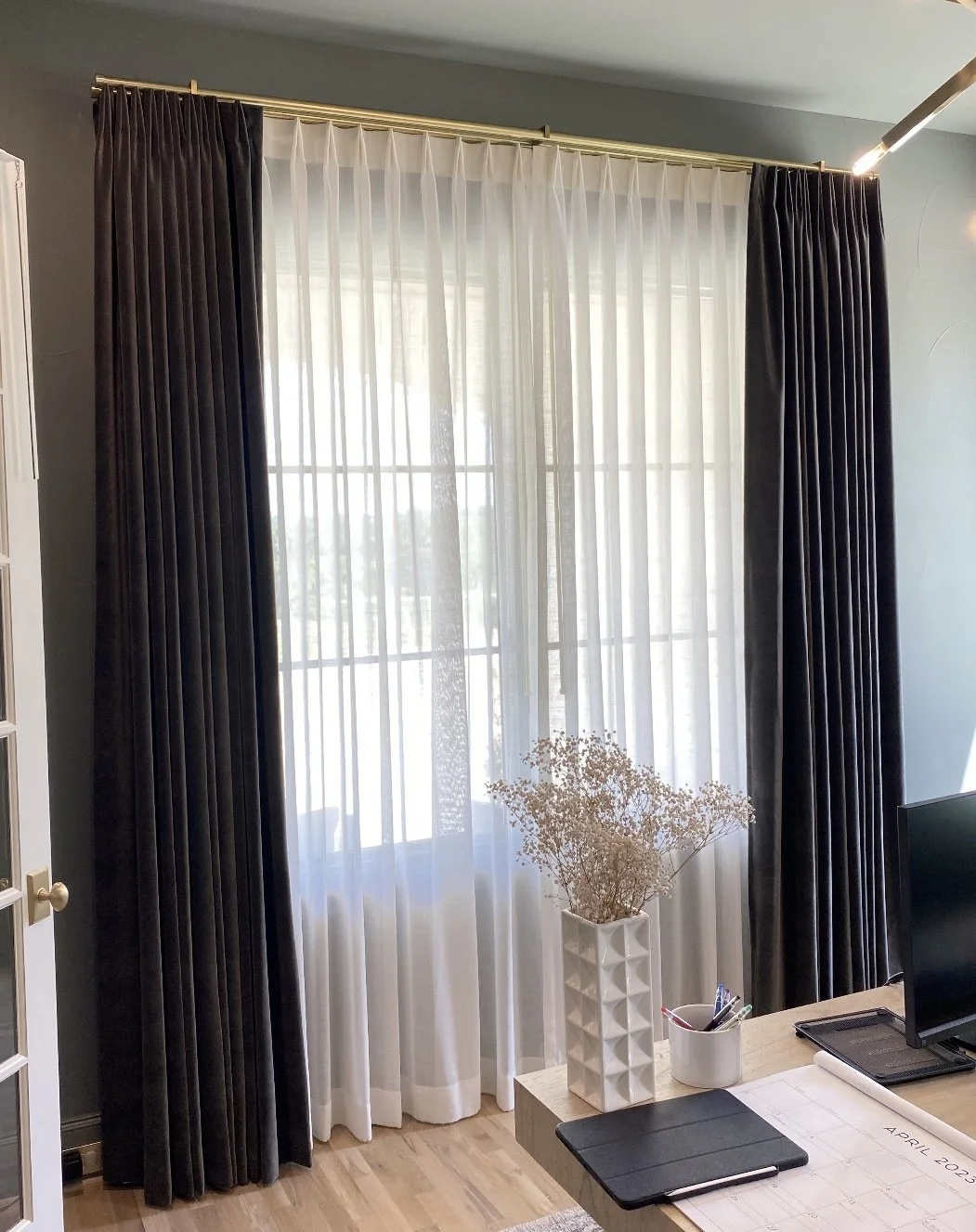 Window treatments, a white sheer curtain with dark blackout curtains.