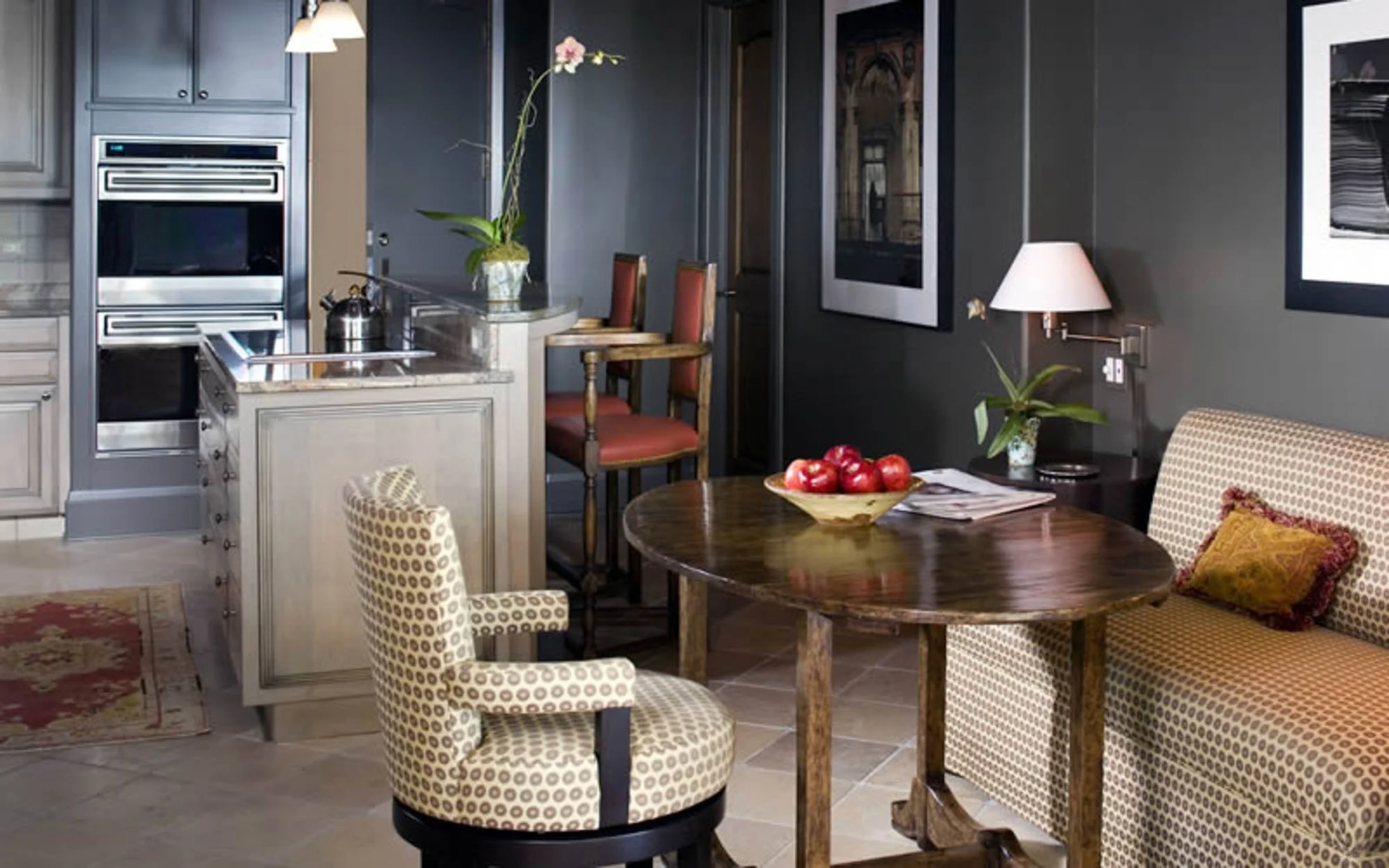 Sophisticated living room with tile floors, patterned beige seating, and a dark wooden table.