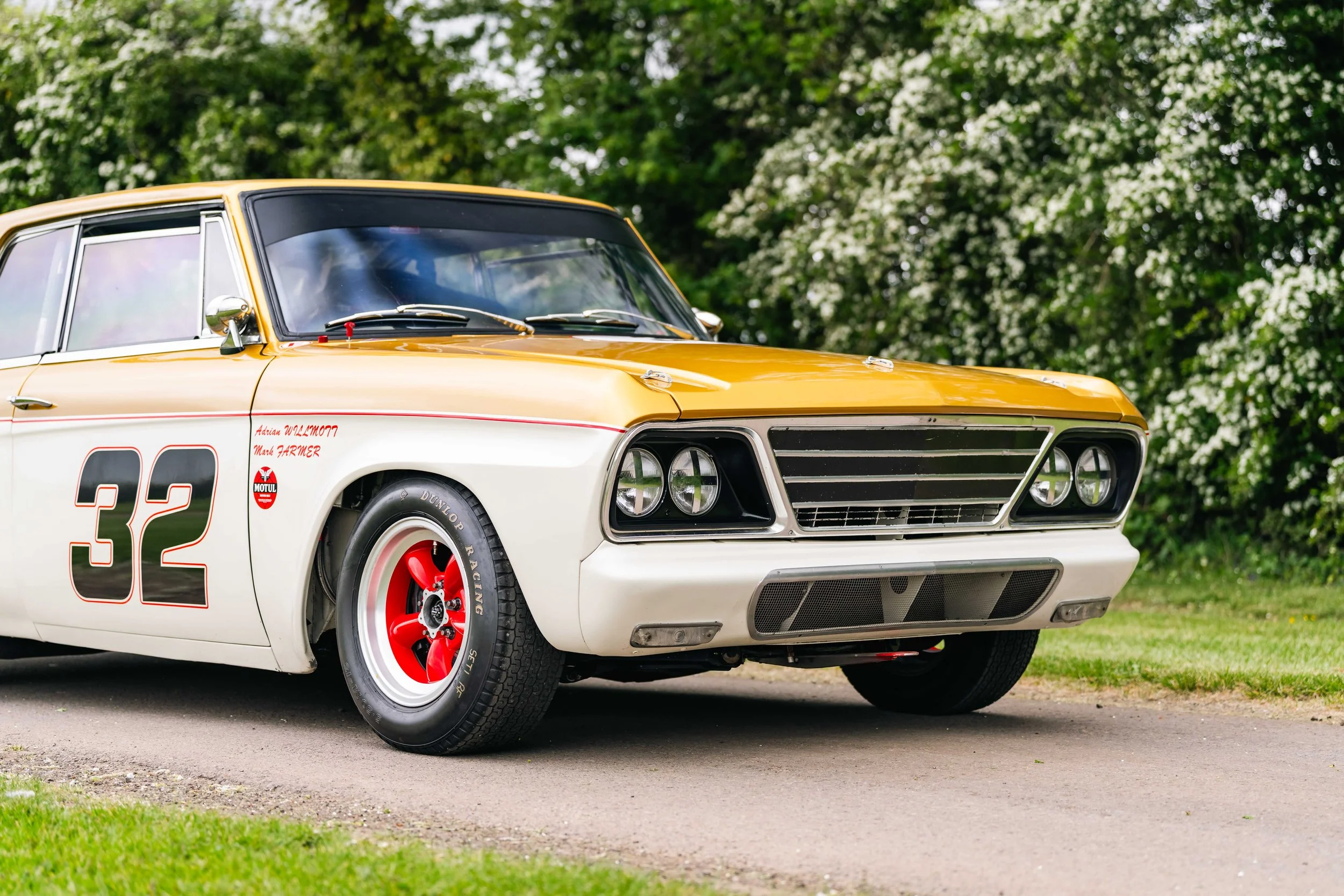 Studebaker Lark Daytona historic touring car. Goodwood. white and gold livery. red wheels.