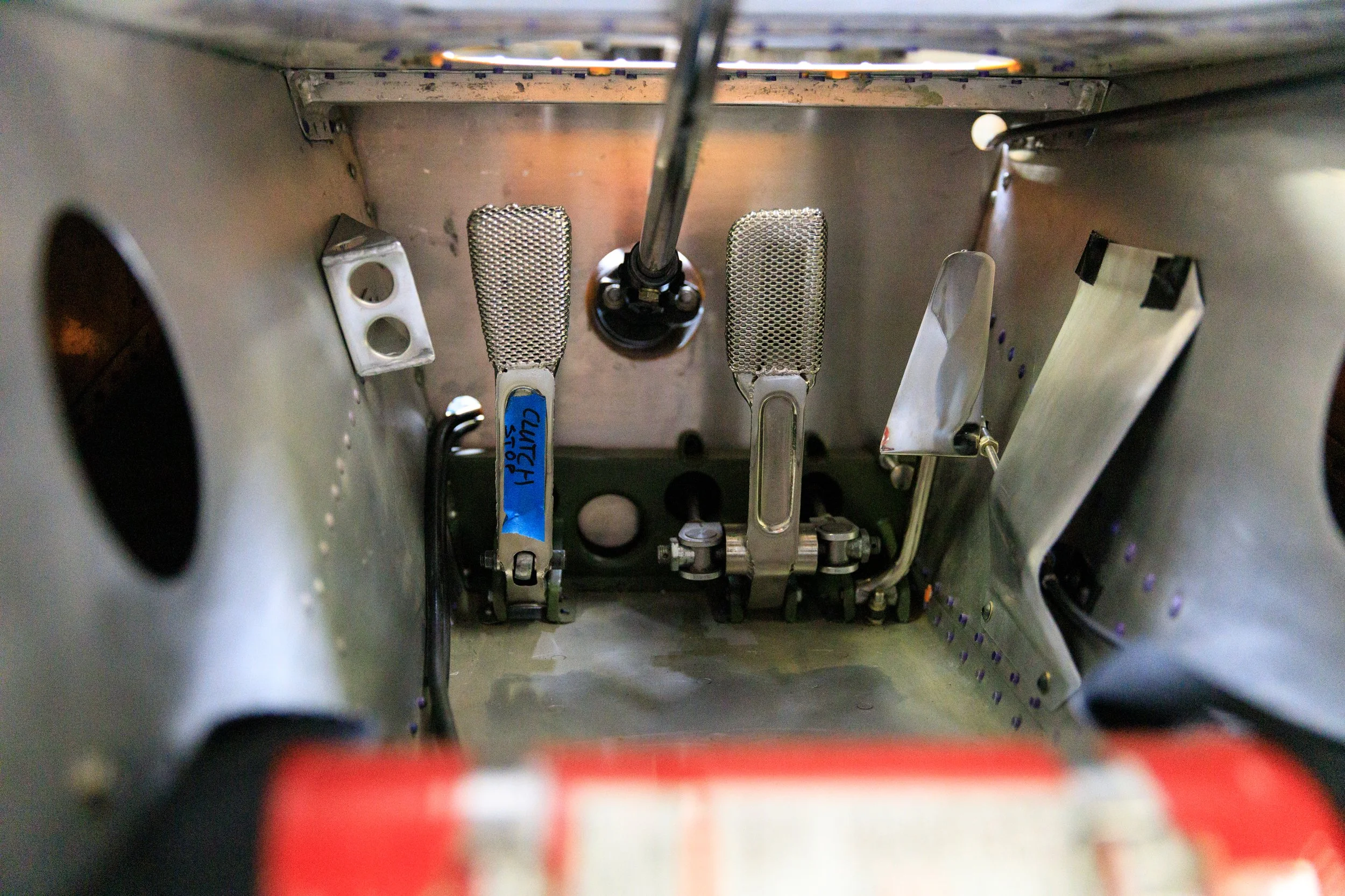 McLaren M21 Formula 2, chassis M21-3 — pedal box detail, brake and throttle pedals, bare aluminium monocoque floor