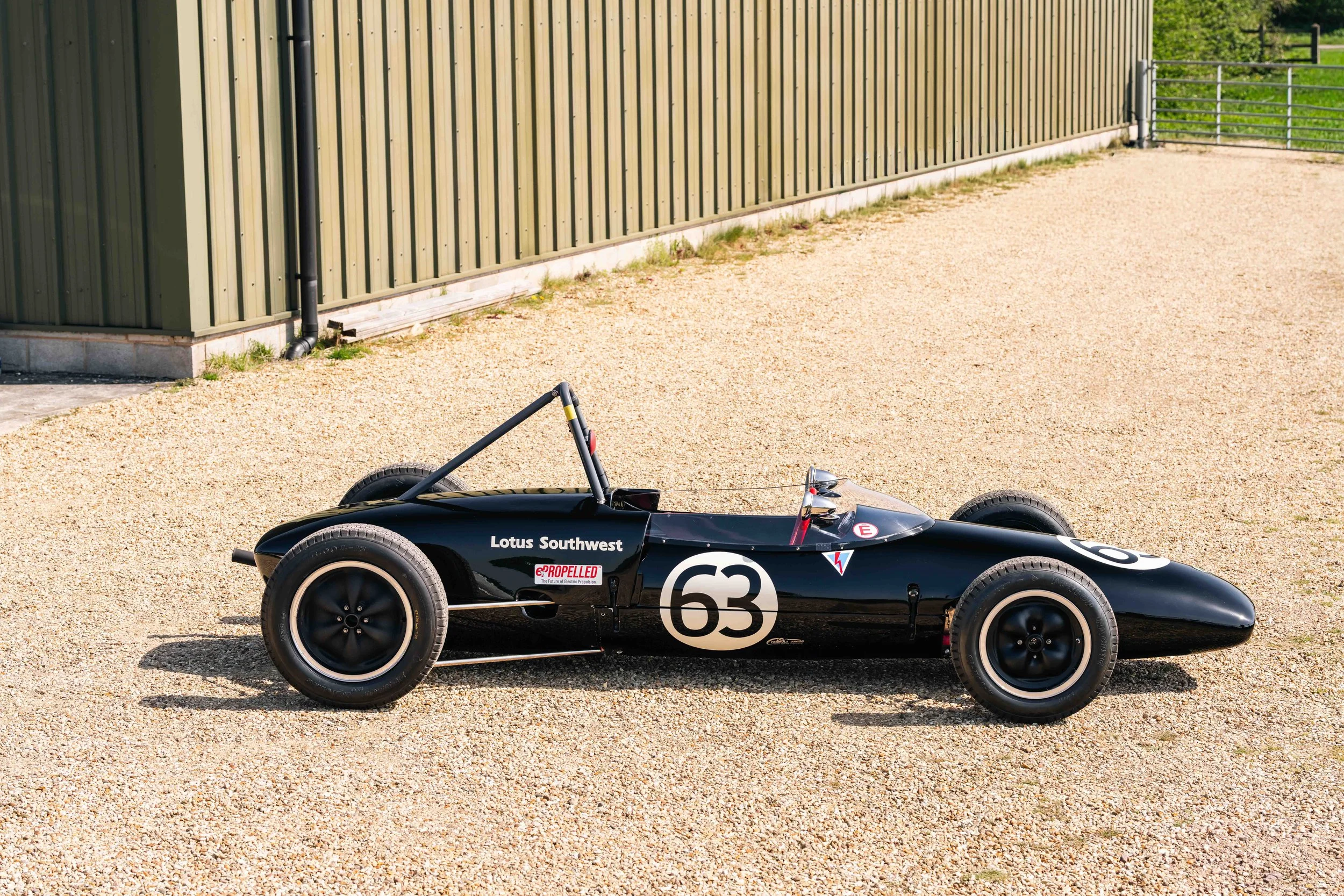 Lotus 20 Formula Junior – driver's side profile, chassis 20-J-905, black livery, open cockpit and spaceframe visible