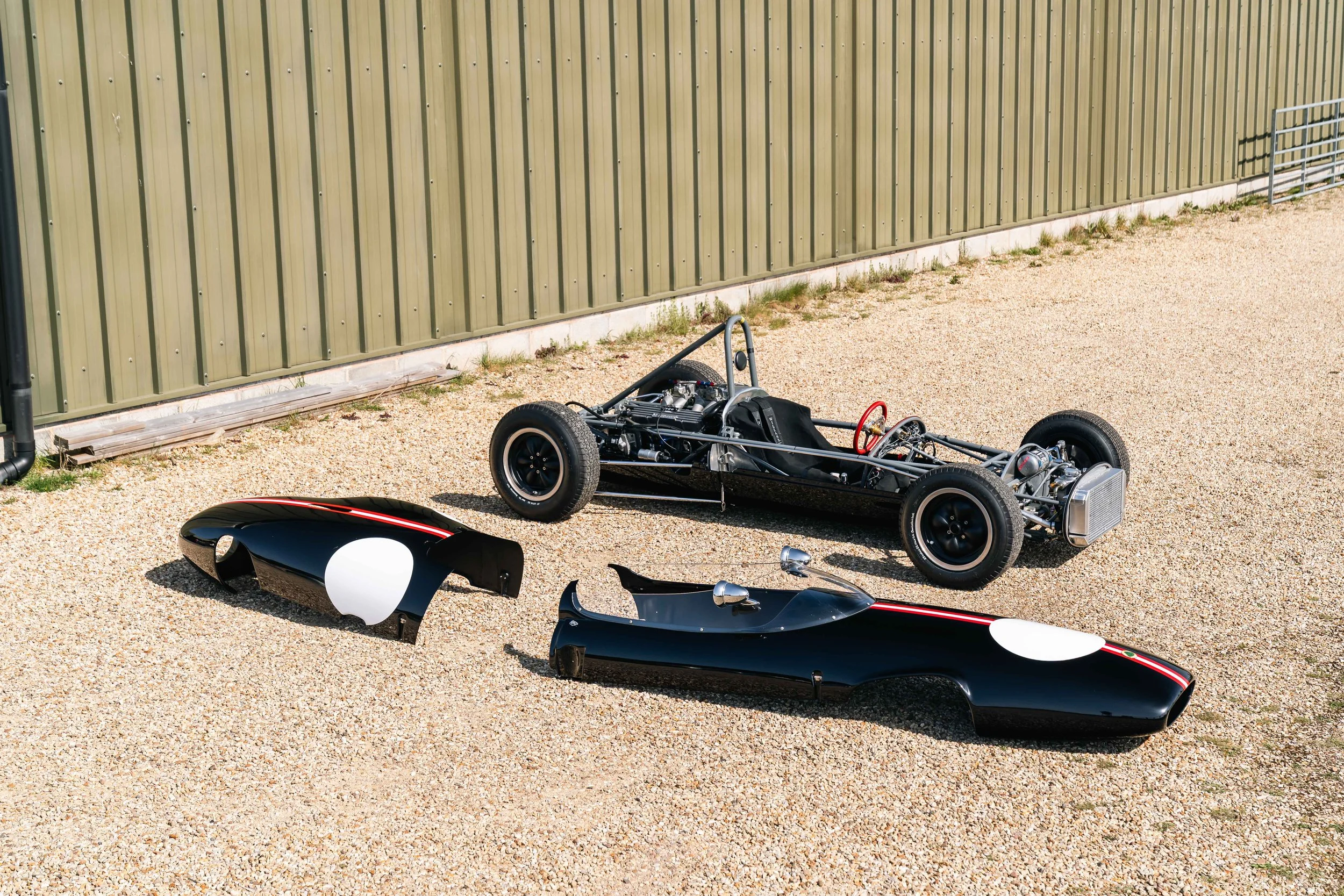 Lotus 22 Formula Junior – rear three-quarter with bodywork beside, chassis 22-J-39, spaceframe and drivetrain exposed