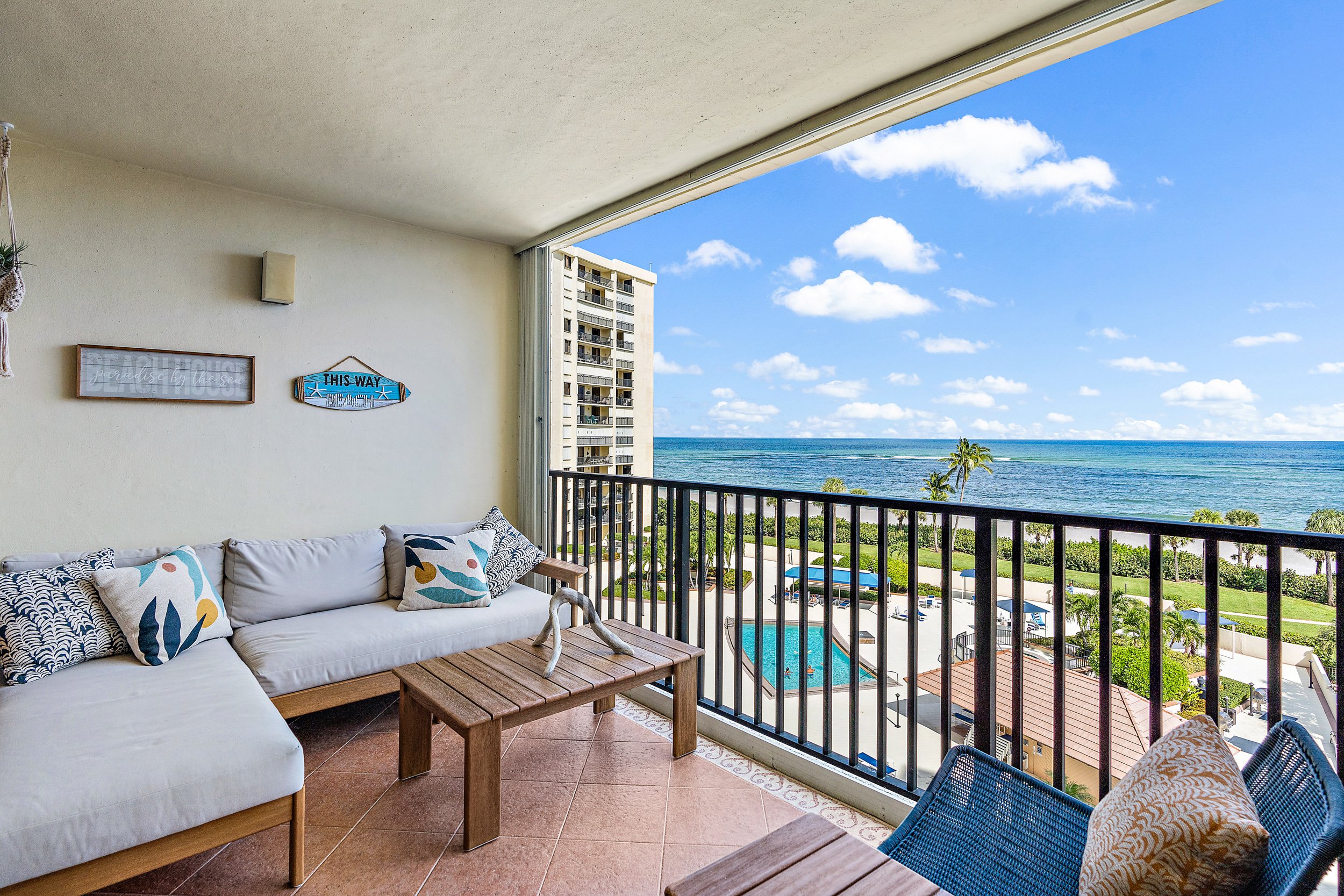 Ocean View Balcony With an Outdoor Chaise Couch, Coffee Table, and Double Lounge Chairs