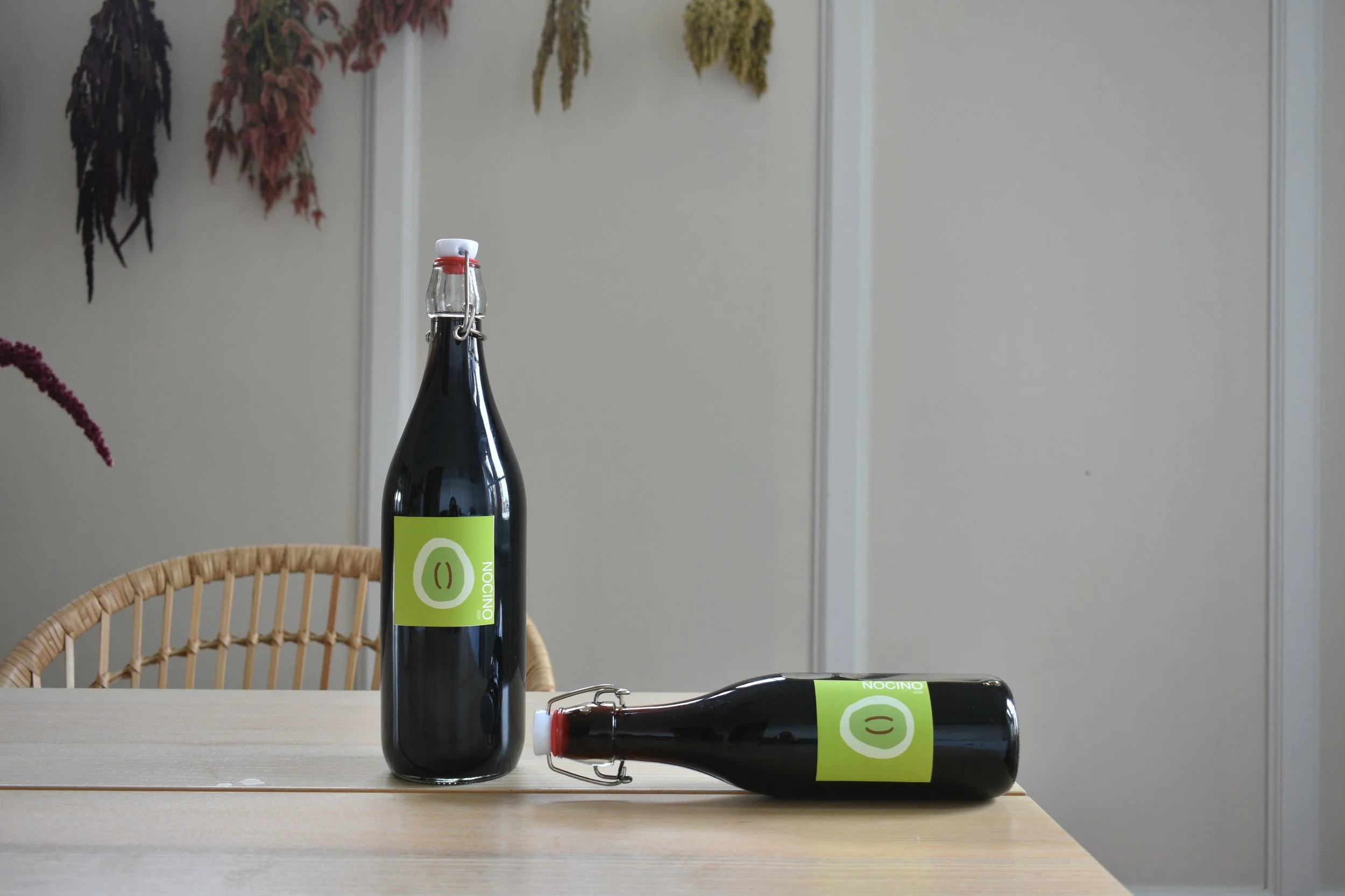 Two bottles of nocino on a wooden table