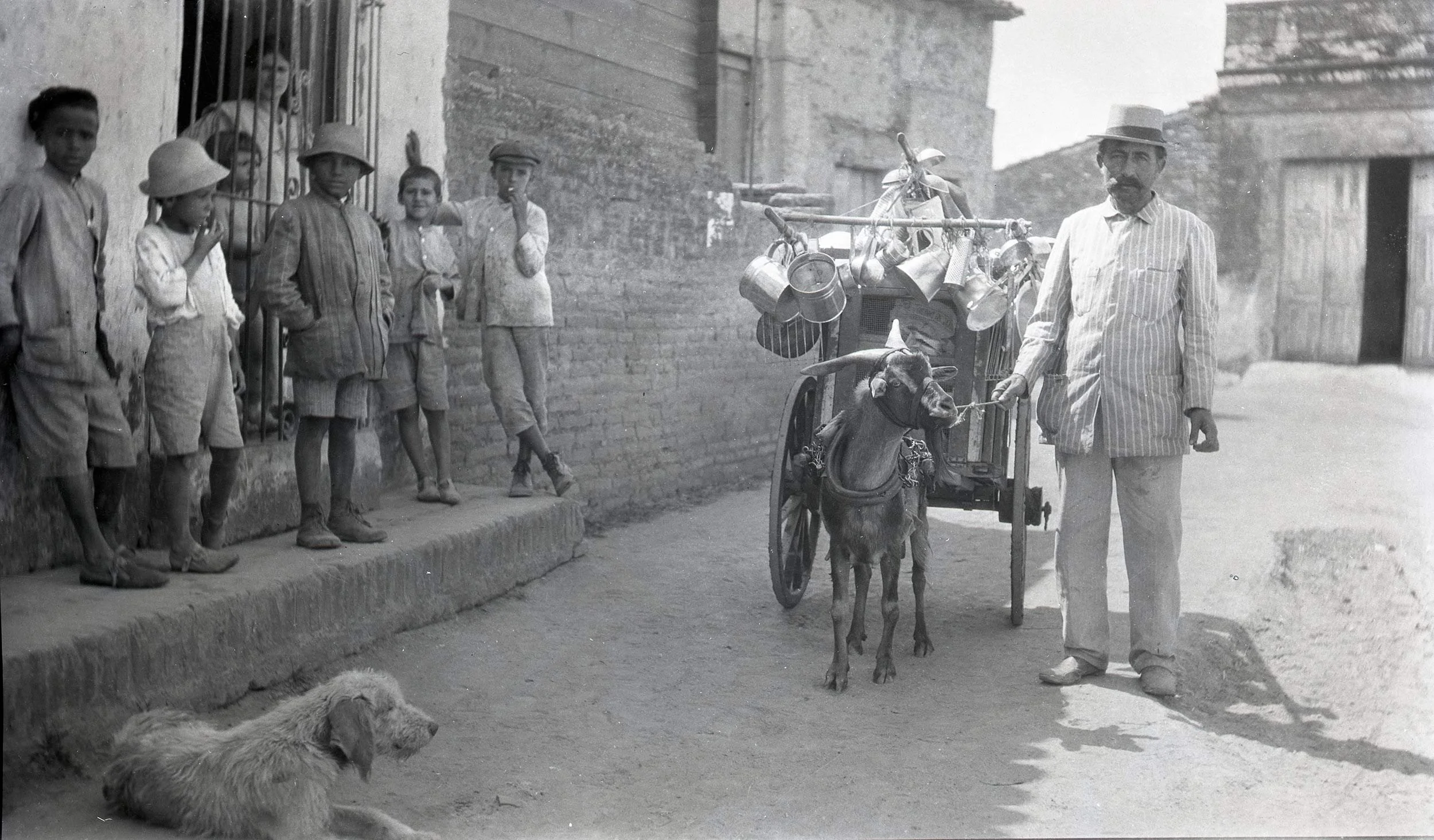 Circa early 1900s historic photograph of street vendor, children, and dog in Cuba.