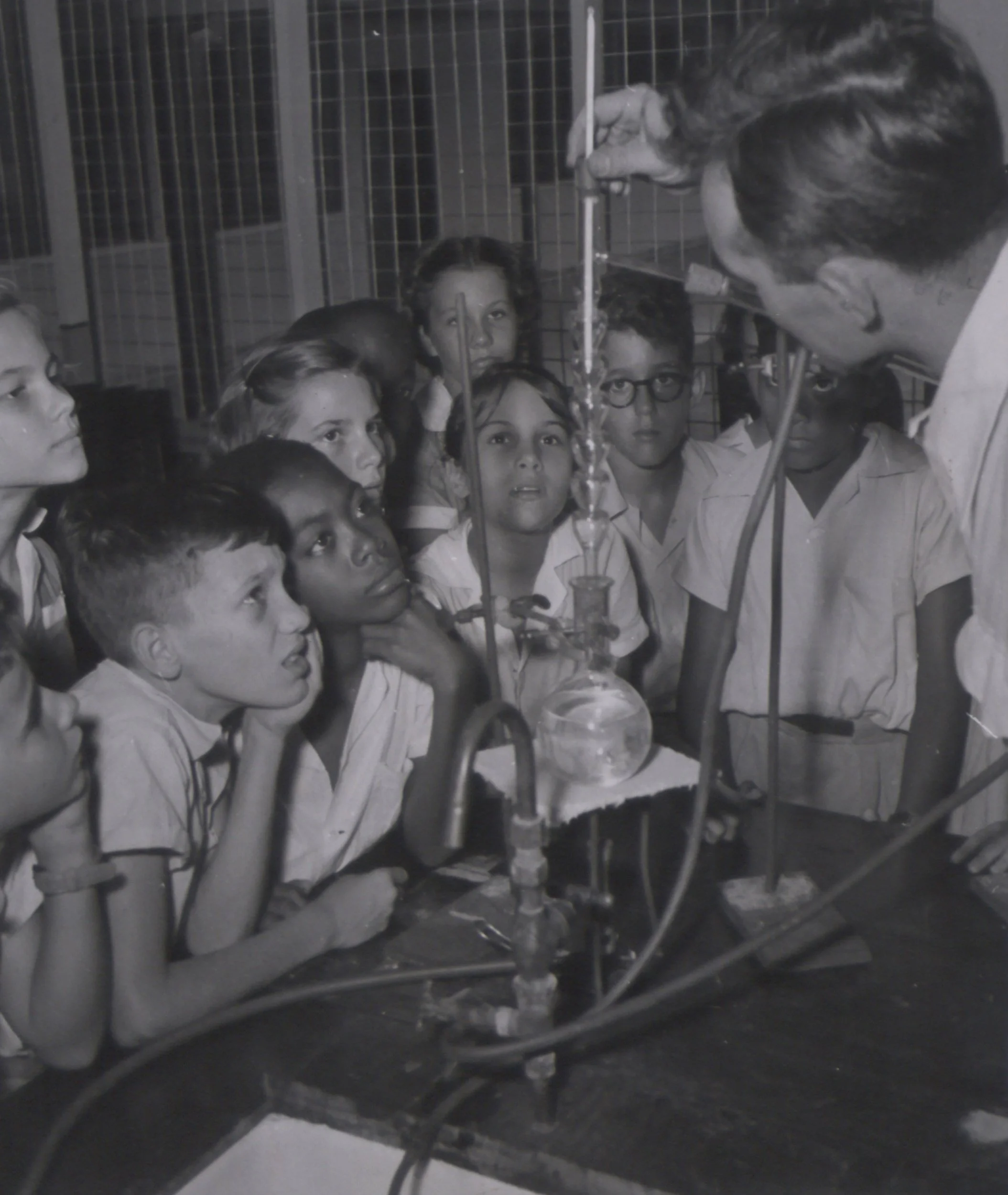 Black and white photograph dated 1955 of a science class in the laboratory of the co-educational school for senior staff children at Pointe-a-Pierre, Trinidad and Tobago.