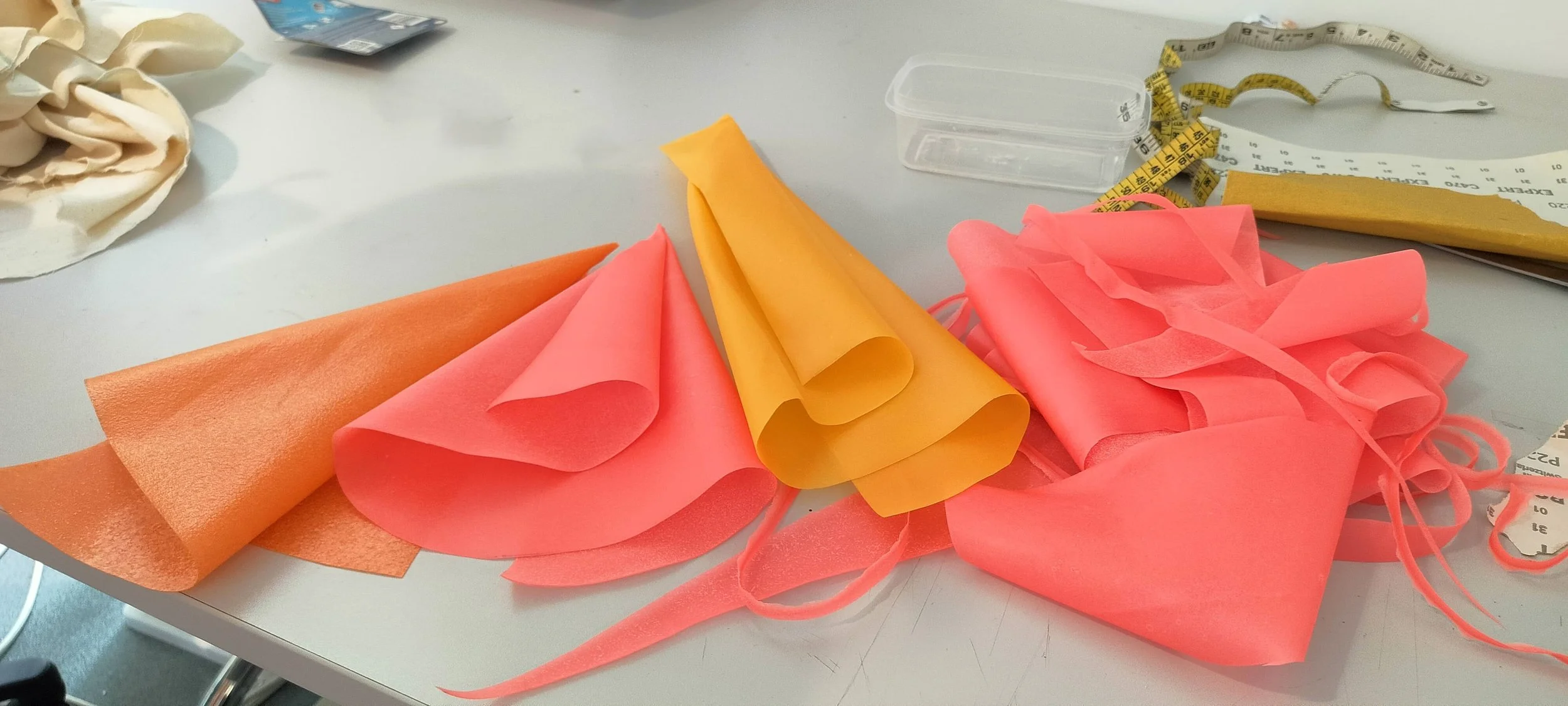 Bioplastic samples folded into delicate forms, glowing softly under light.