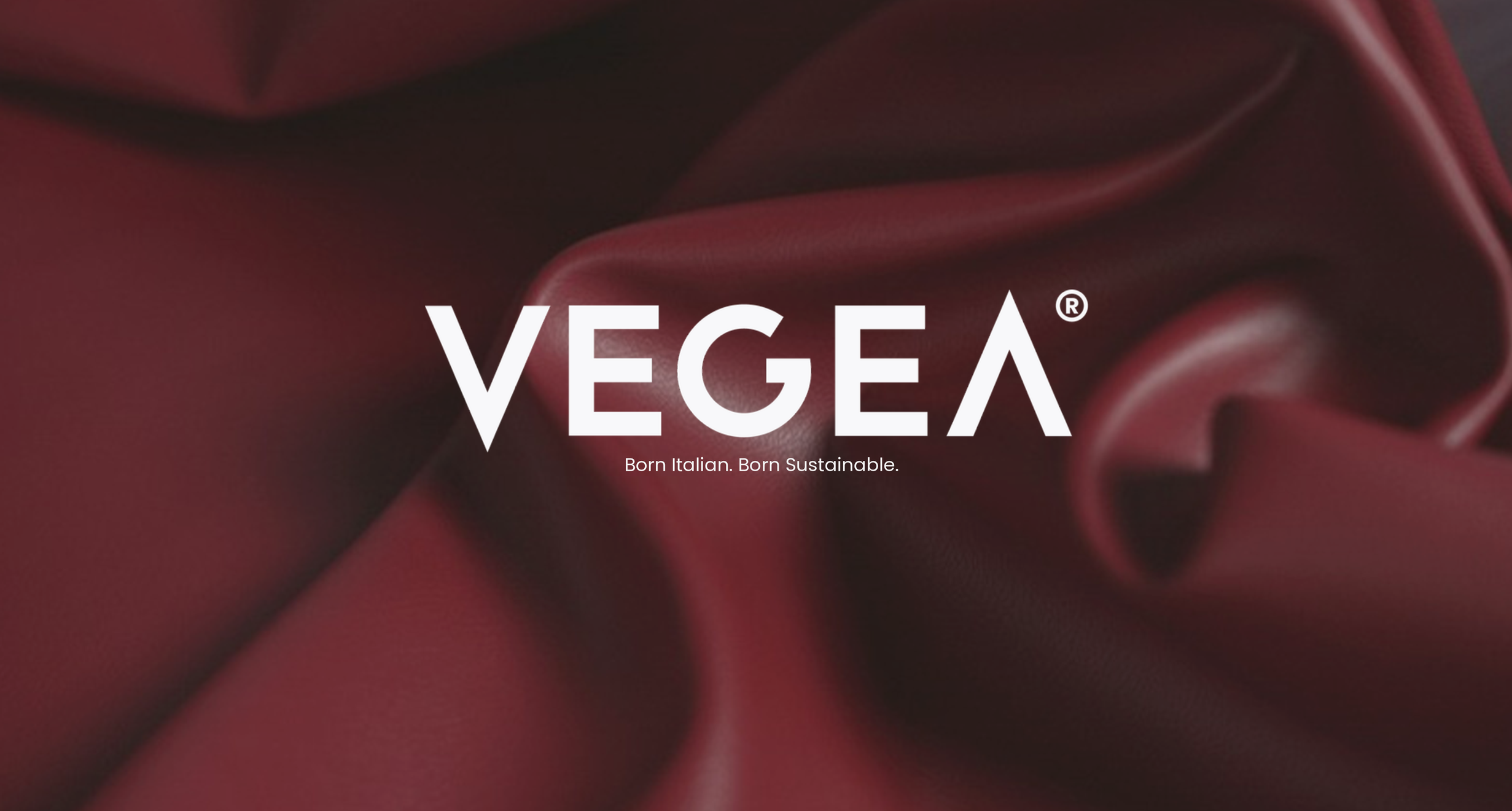 Close-up of Vegea’s deep burgundy GrapeSkin biomaterial draped in soft folds, showcasing the texture and finish of the wine-derived sustainable material developed from grape marc by-products.