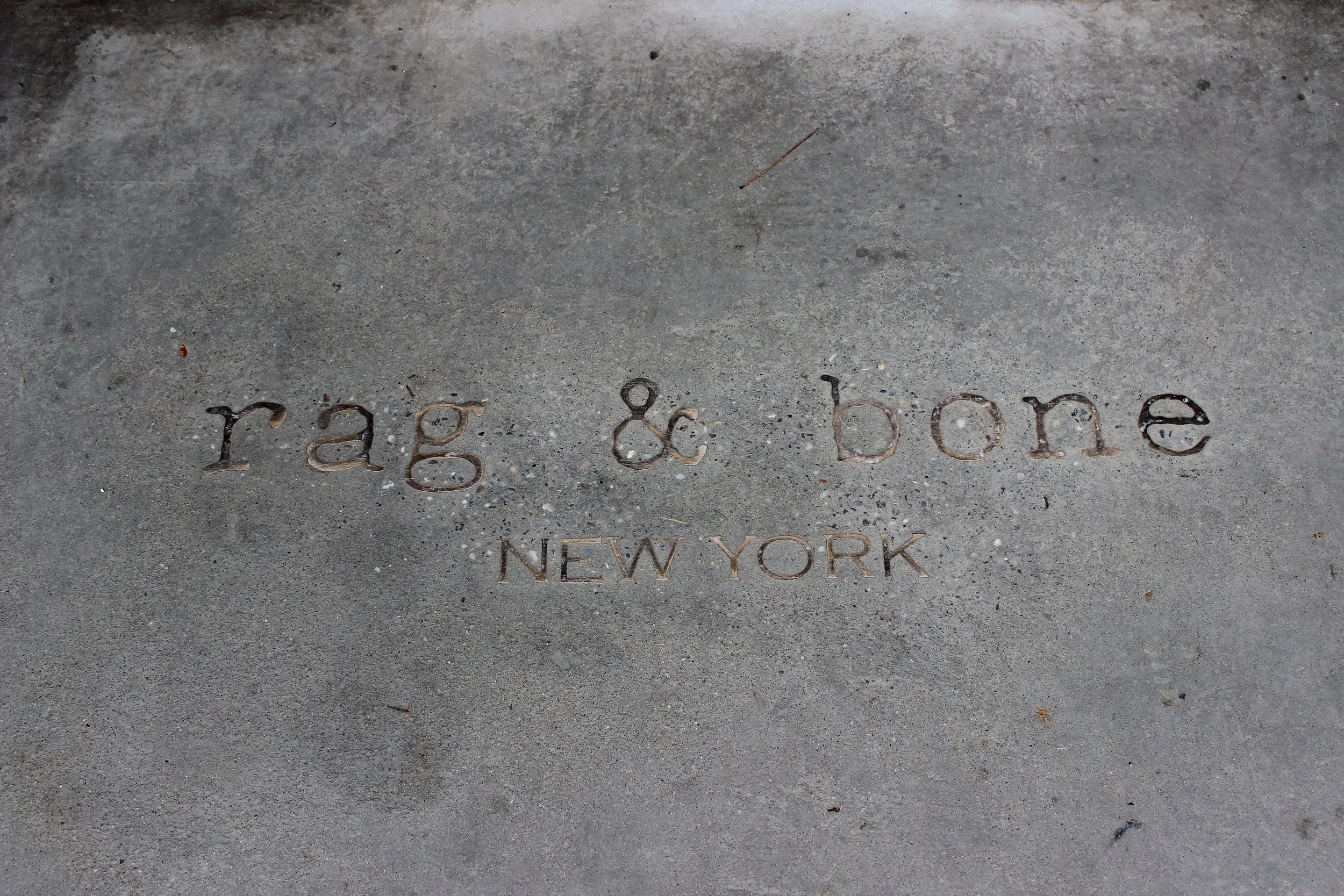 Close-up of Rag & Bone New York branding engraved into a concrete surface