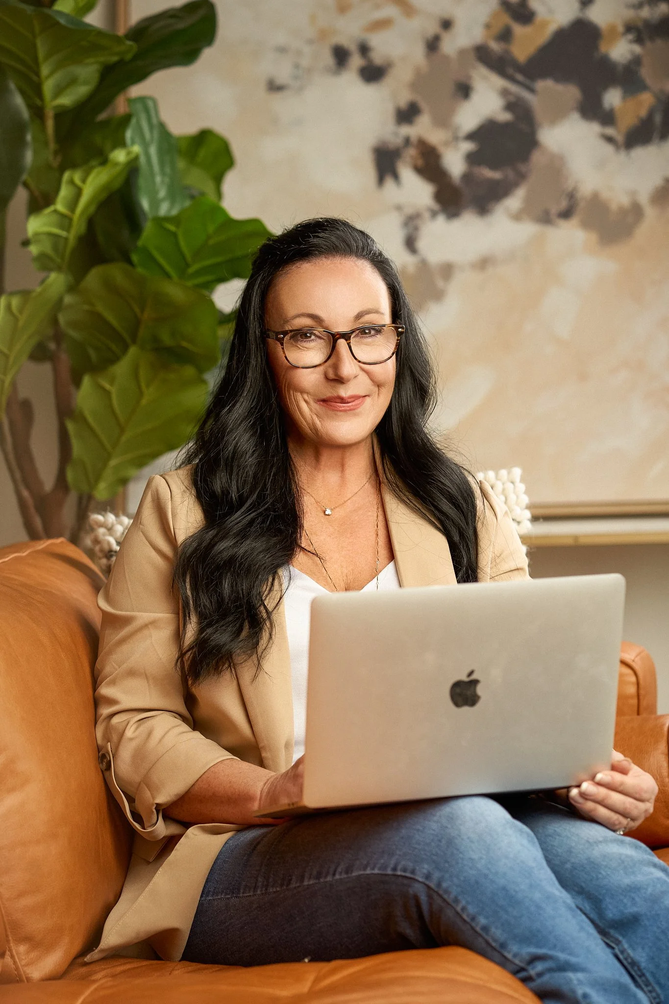 woman on leather couch with laptop
