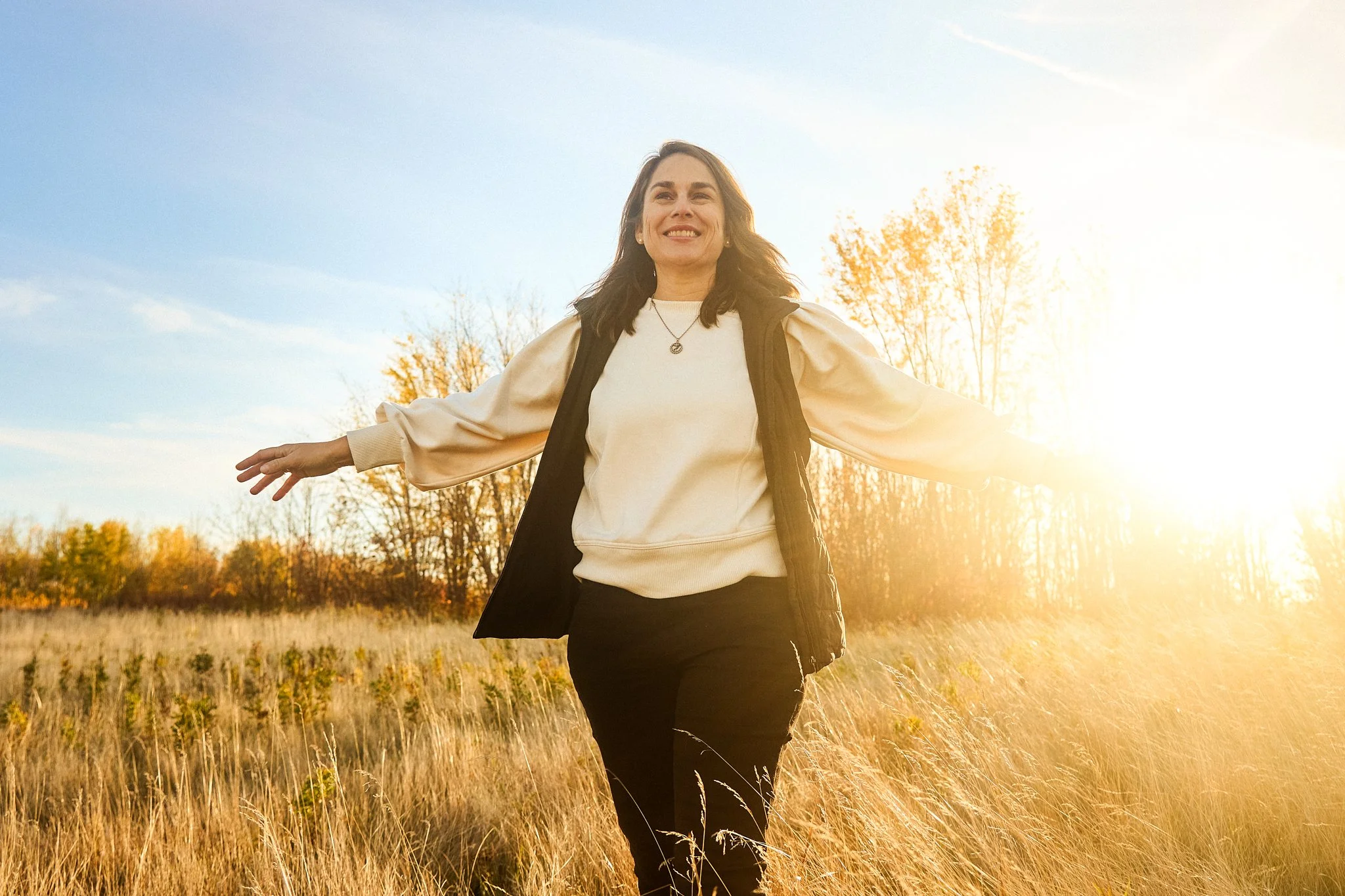 woman in field arms out stretched