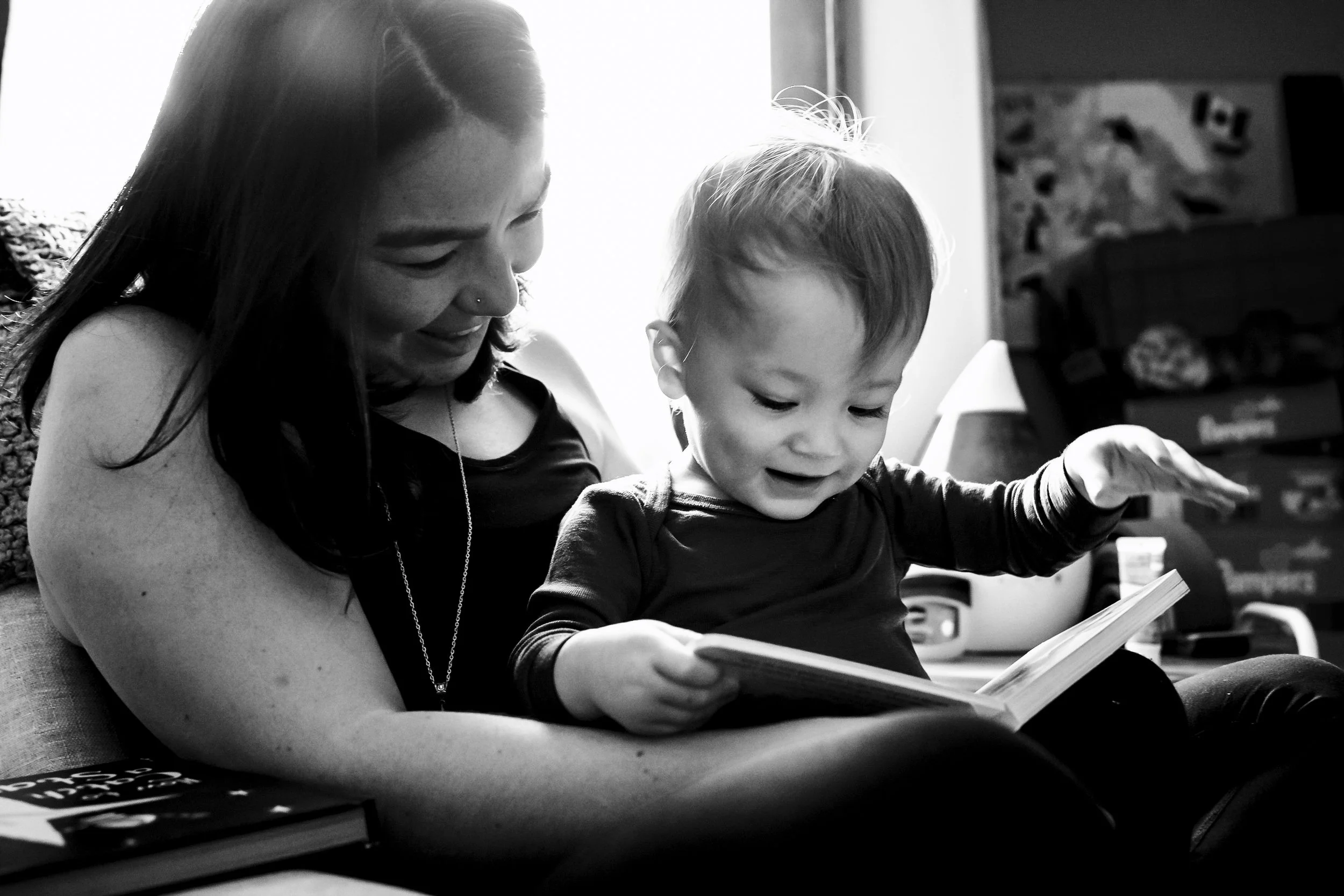 Mom reading a book with her toddler during a documentary family photography session in Calgary