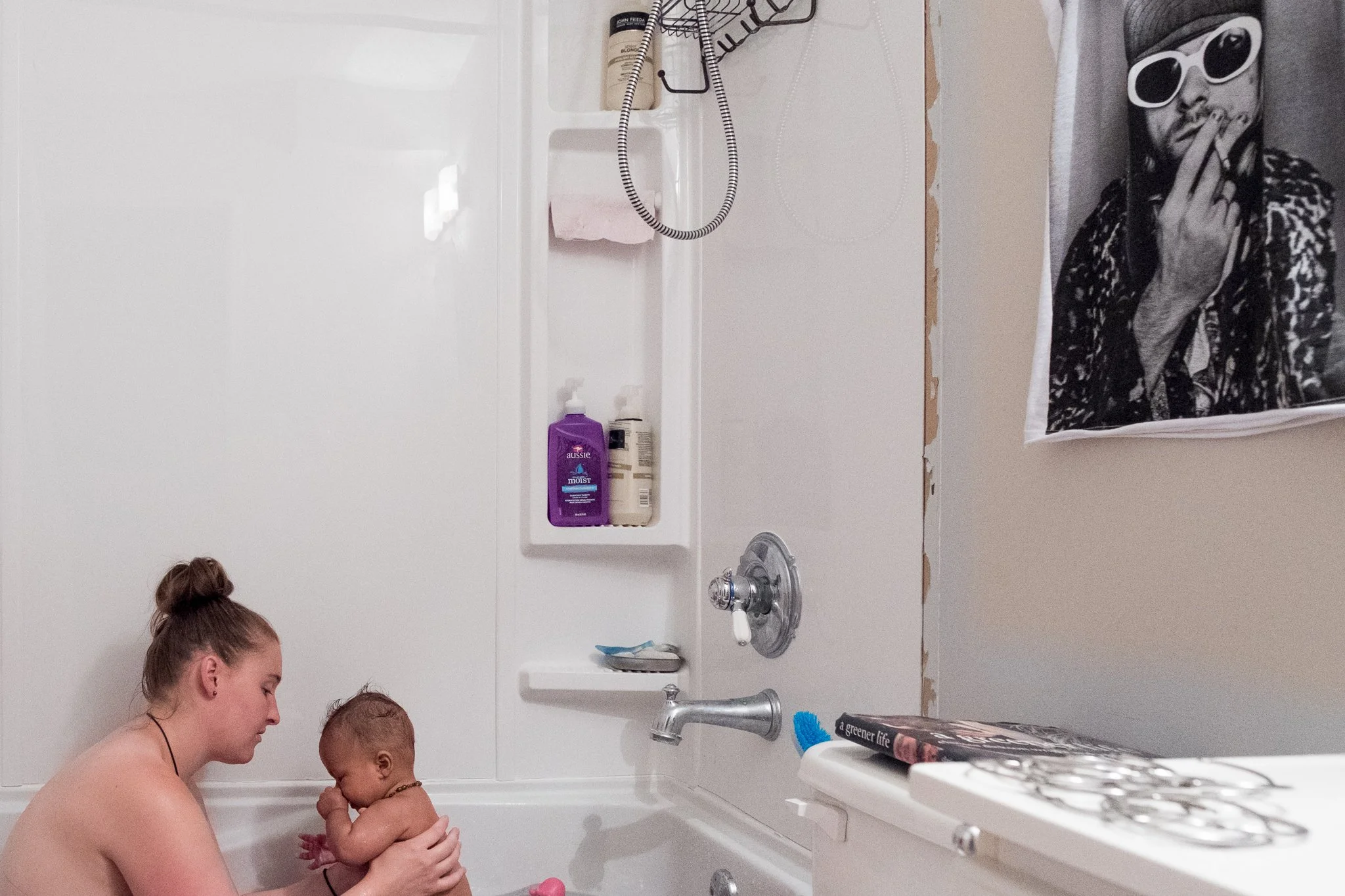 Mom bathing her young child during an everyday family routine