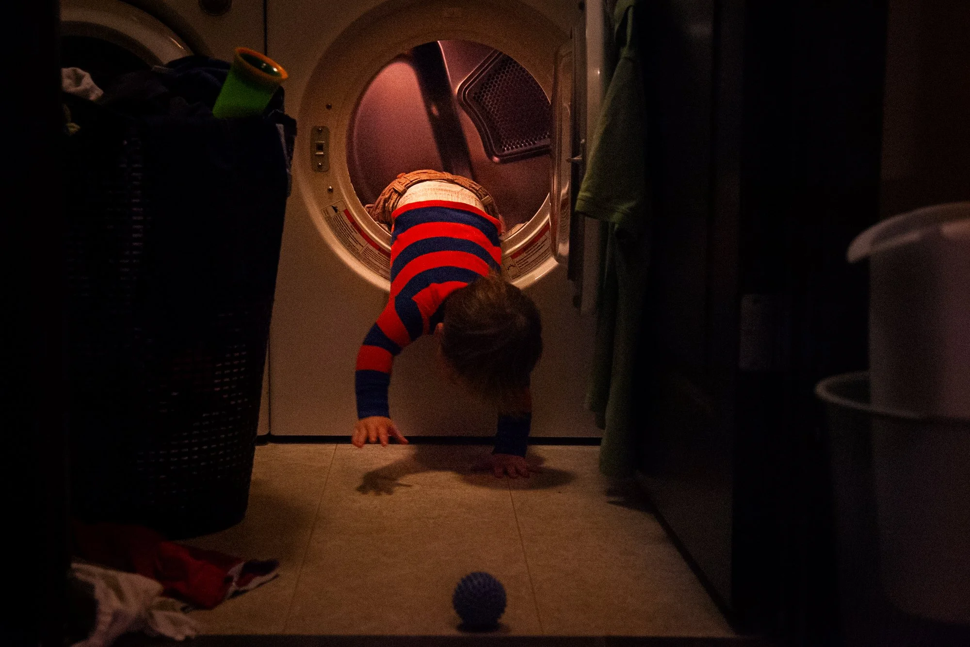 toddler crawling out of laundry machine