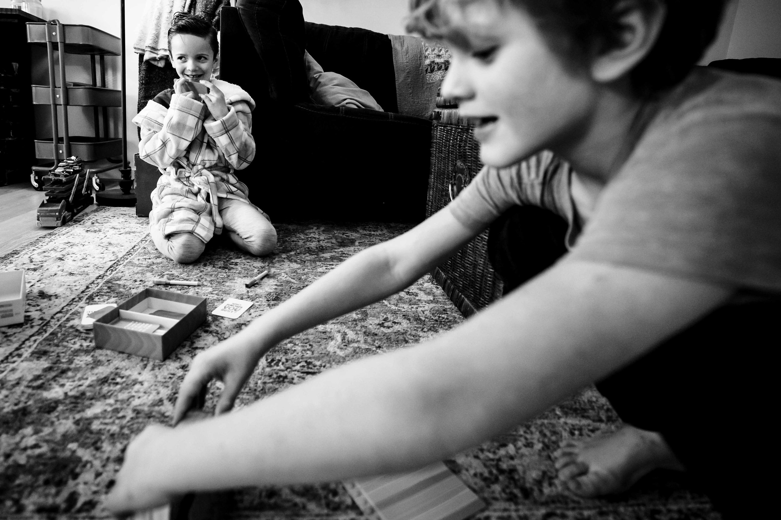 siblings playing a game together on livingroom carpet in Calgary, Alberta