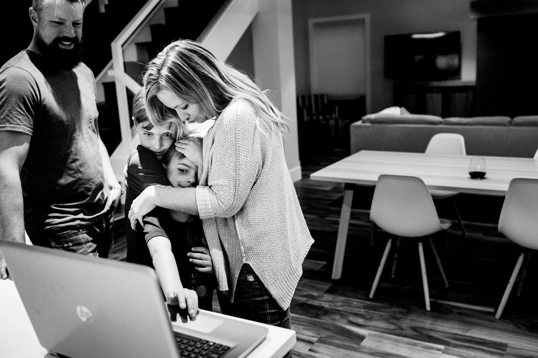 mother hugging both her boys in kitchen in Calgary, Alberta