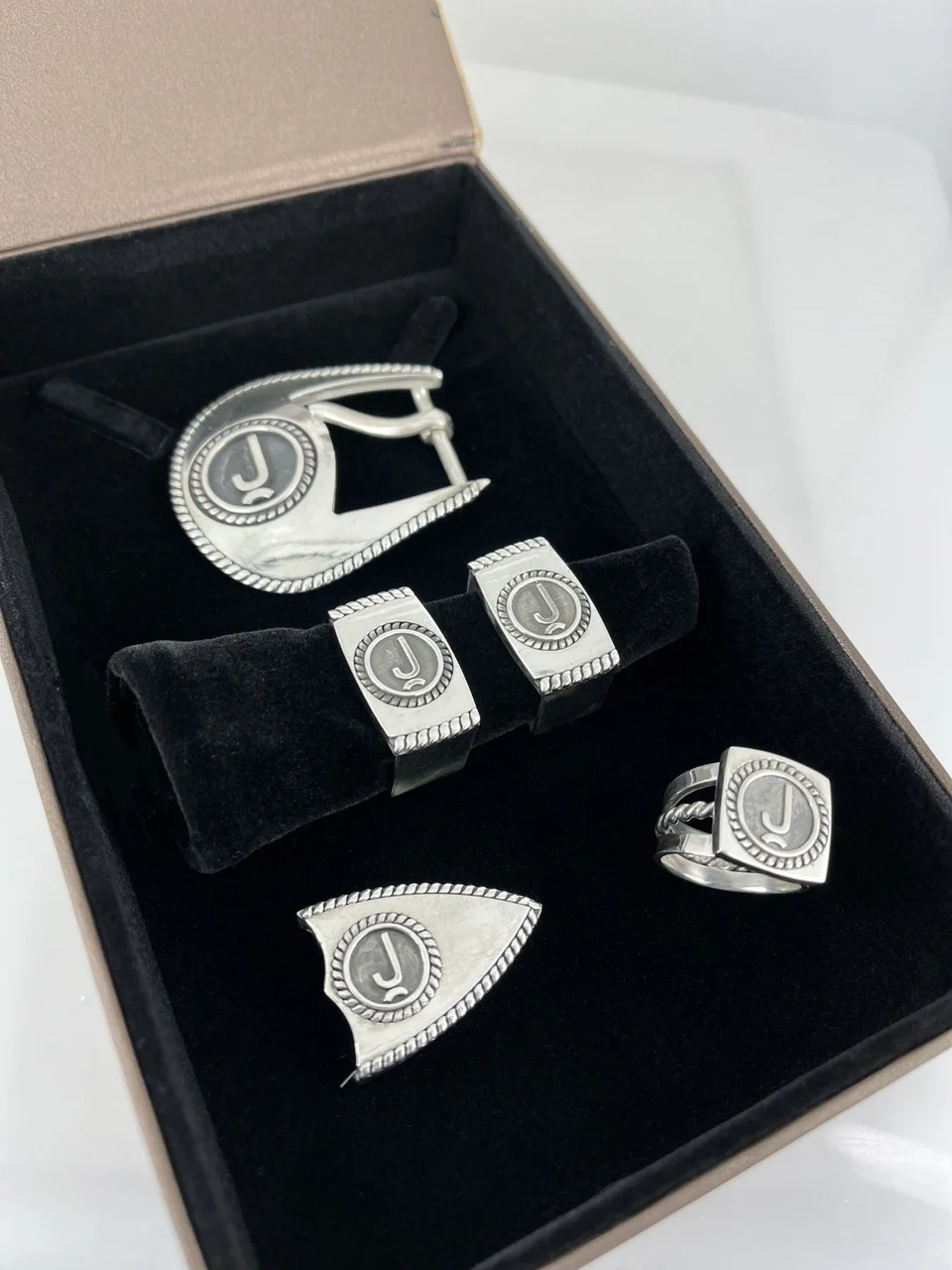 Custom belt buckle and belt accessories with their ranch brand logo on each of the pieces. Matching ring for the belt.