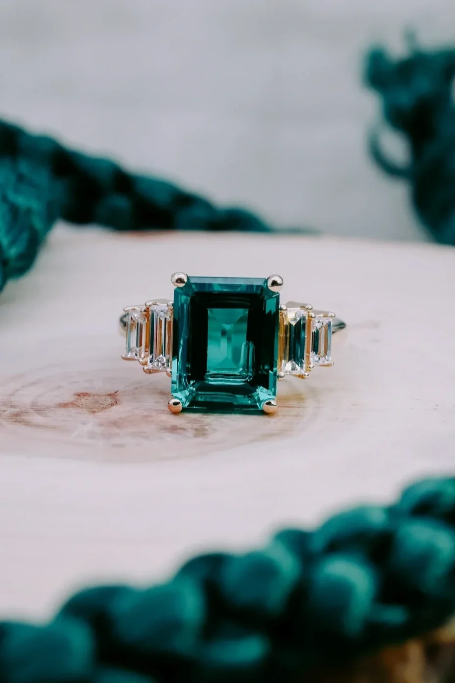 Custom yellow gold emerald ring with baguette side stones
