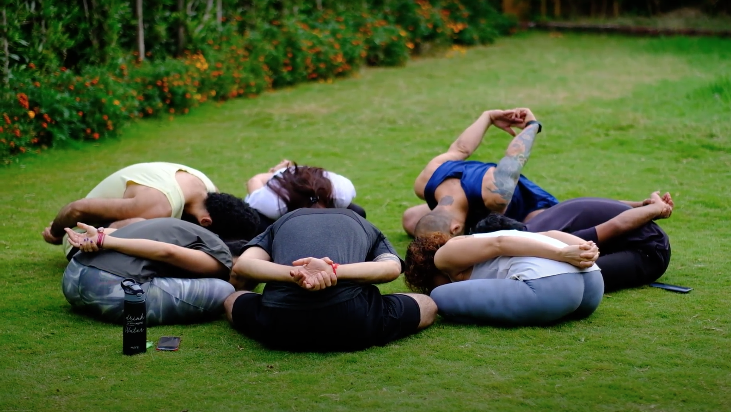 Participants resting together in a star-shaped circle on the grass at a Yukah programme Europe