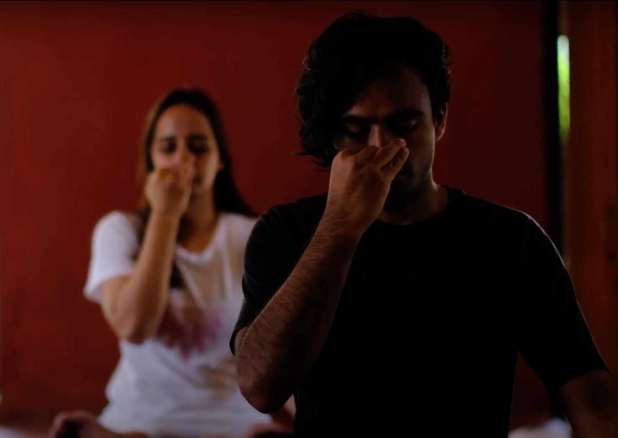 Two participants practising alternate nostril breathing in a pranayama session at Yukah.