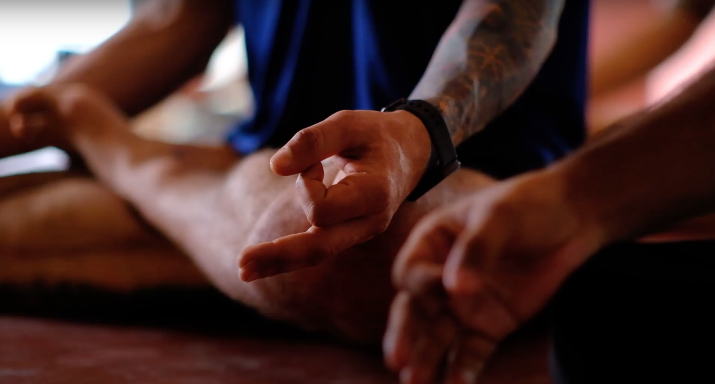 A participant’s hands resting in a meditation mudra at a Yukah programme.