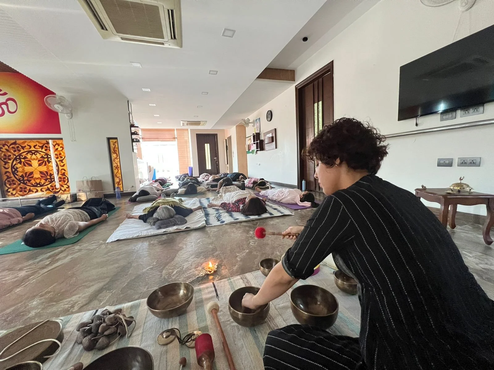 Aarti Babhoota setting out singing bowls for a Nada Yoga sound session at Yukah.