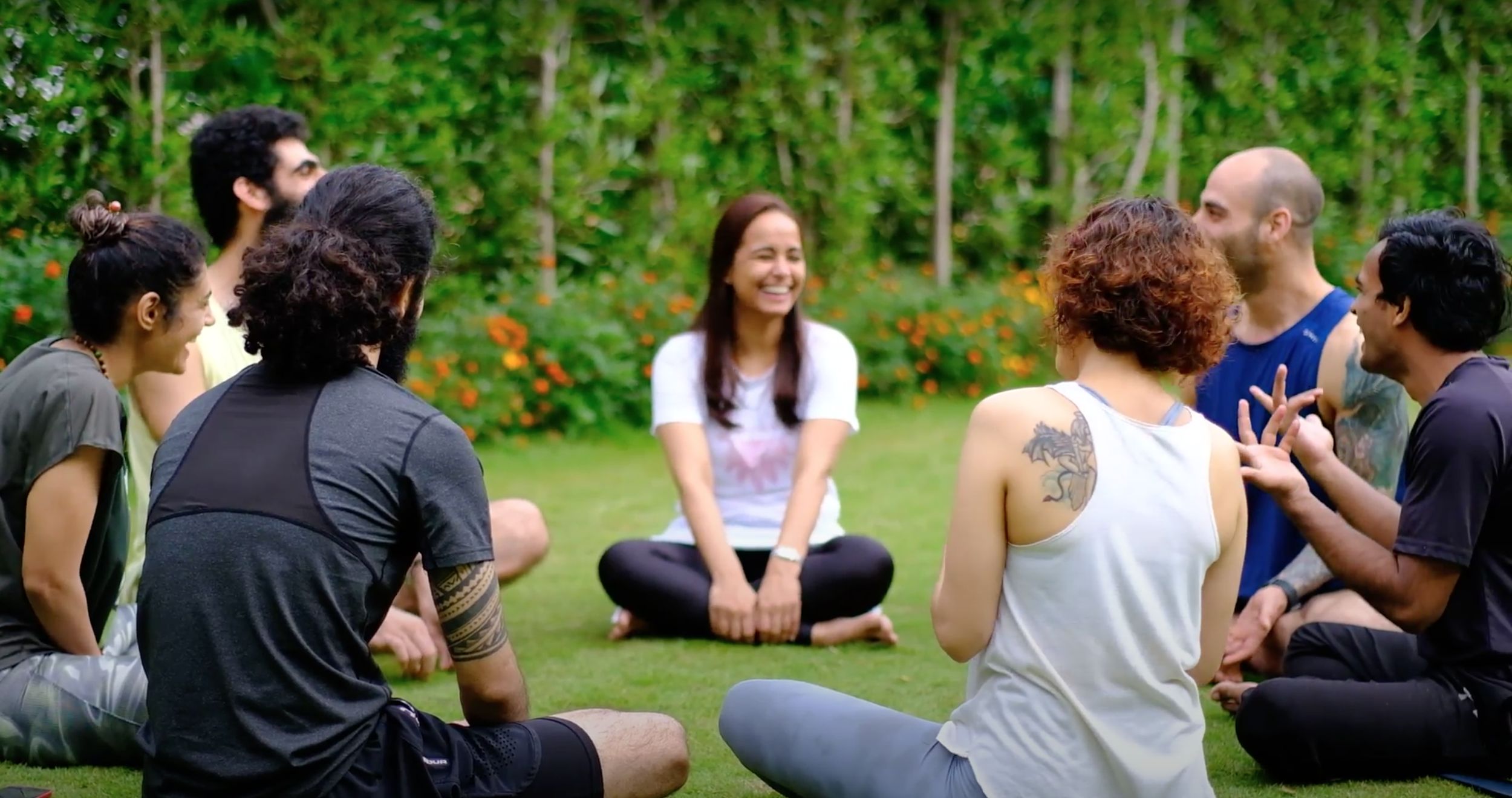 Participants laughing in a sharing circle on the lawn at a Yukah programme.