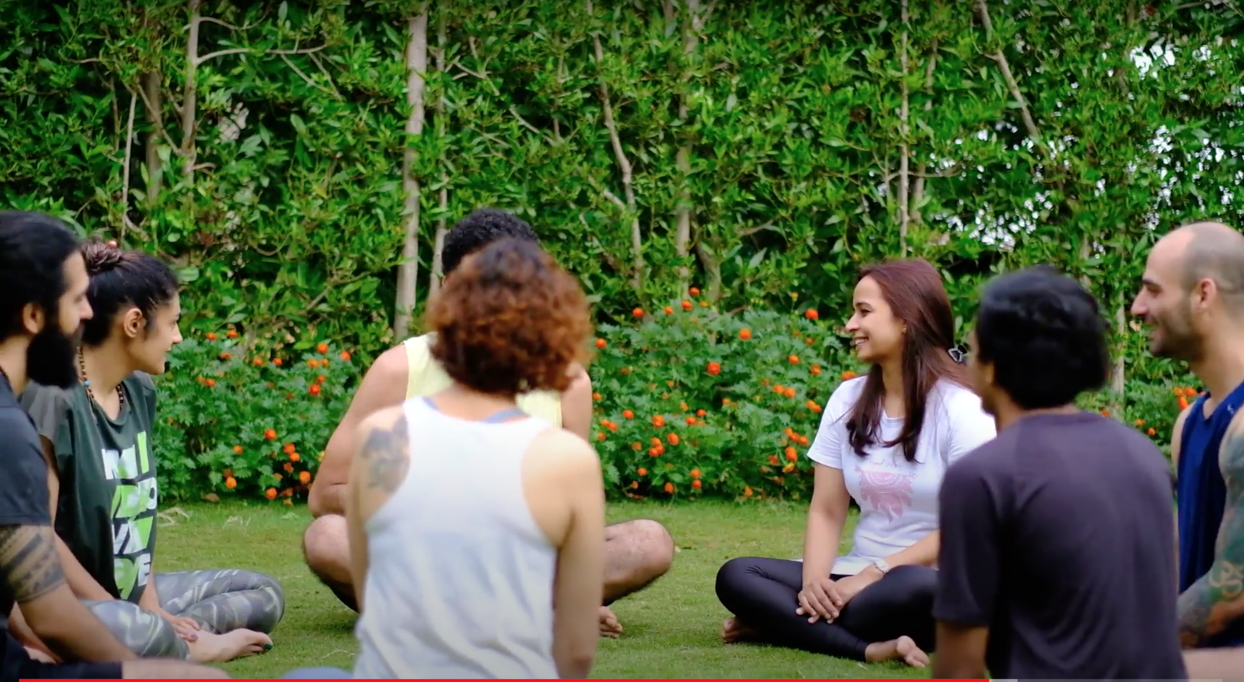 Participants talking in a sharing circle on the lawn at a Yukah programme.