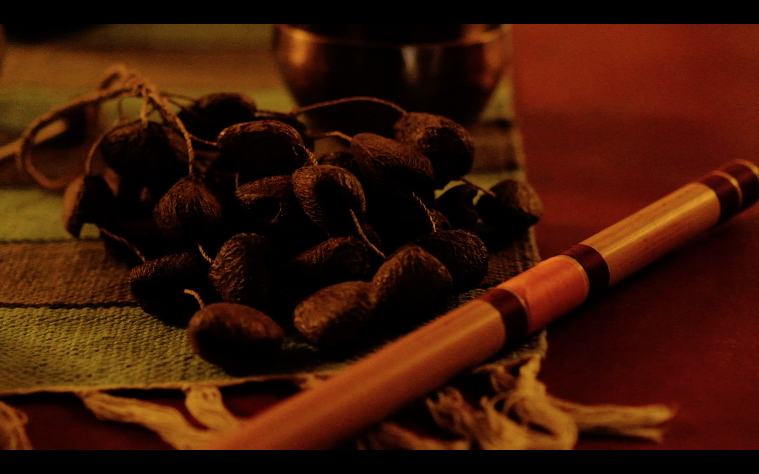 A bamboo flute and seed-pod rattle laid out for a Nada Yoga session at Yukah.