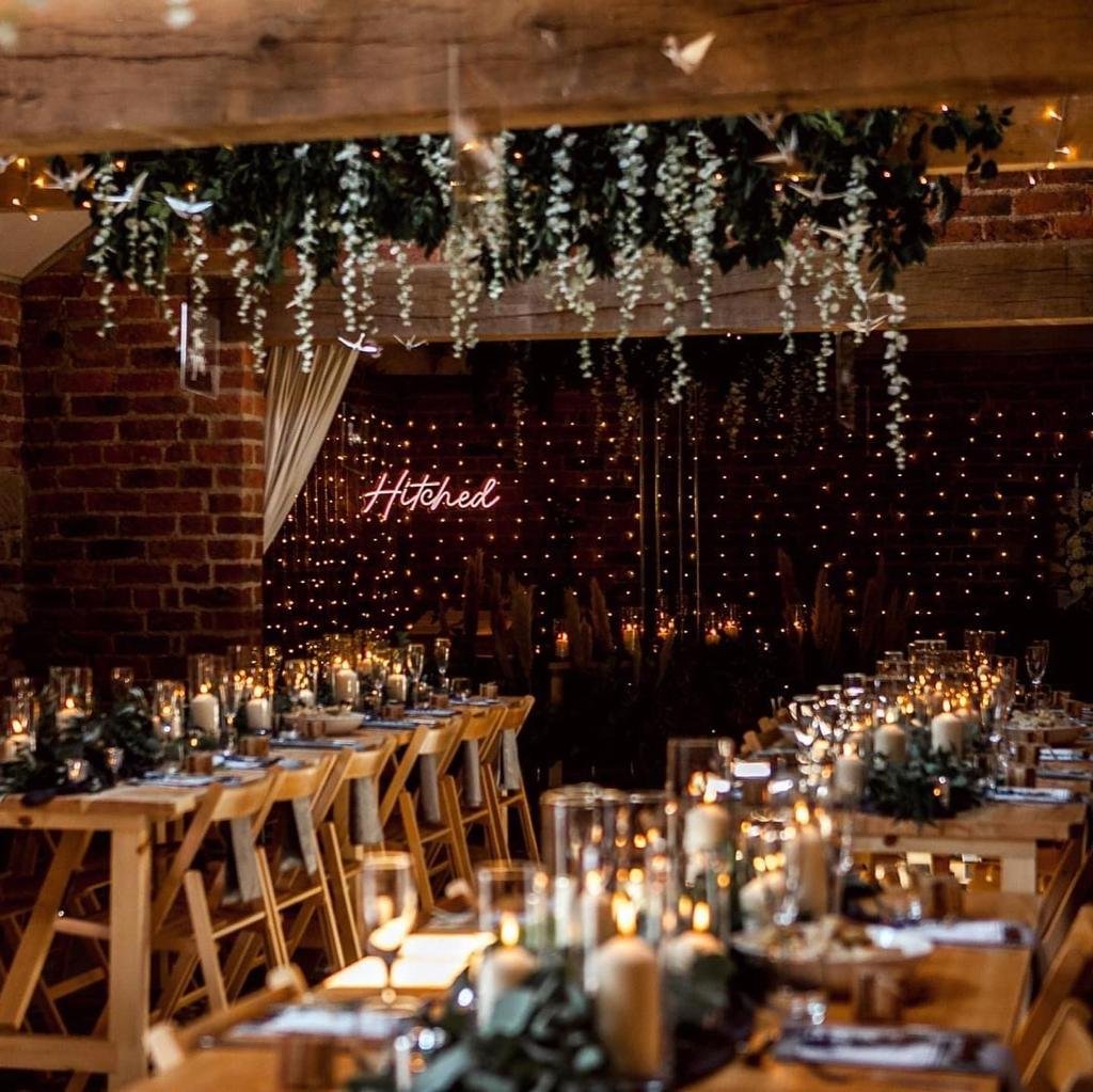 barn decorated with lights and candles for wedding with tables and chairs
