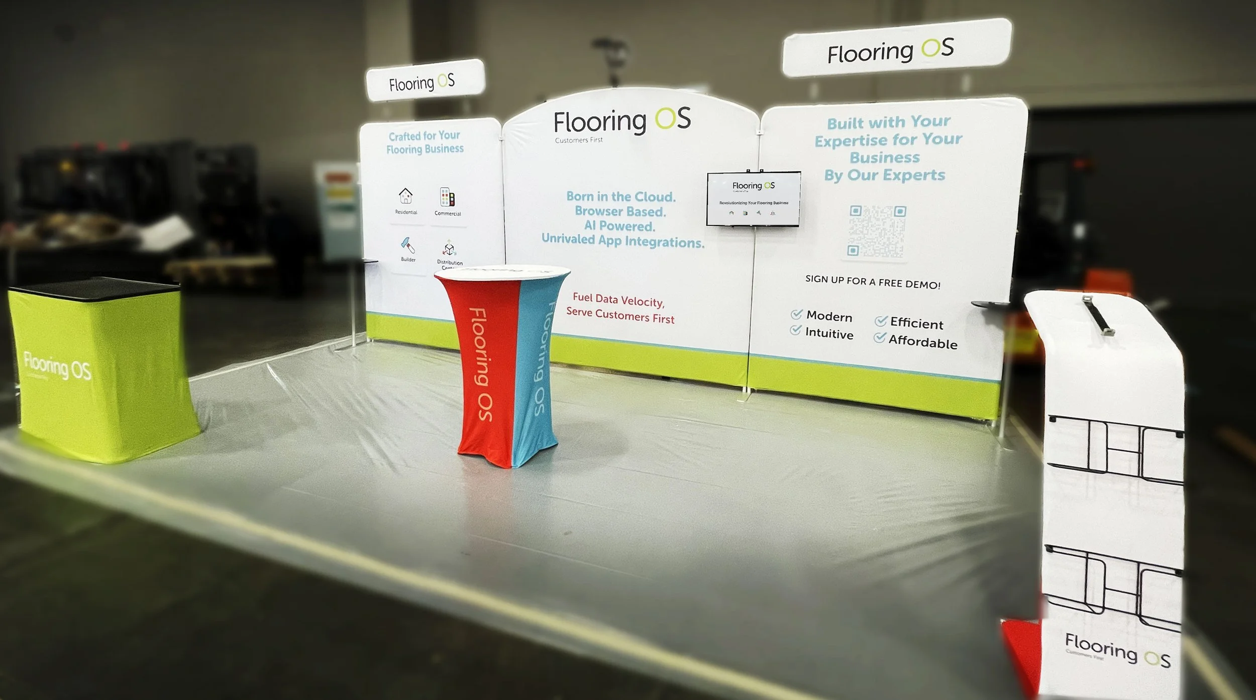 Exhibition booth for Flooring OS with banners, a table, and a QR code for demos.