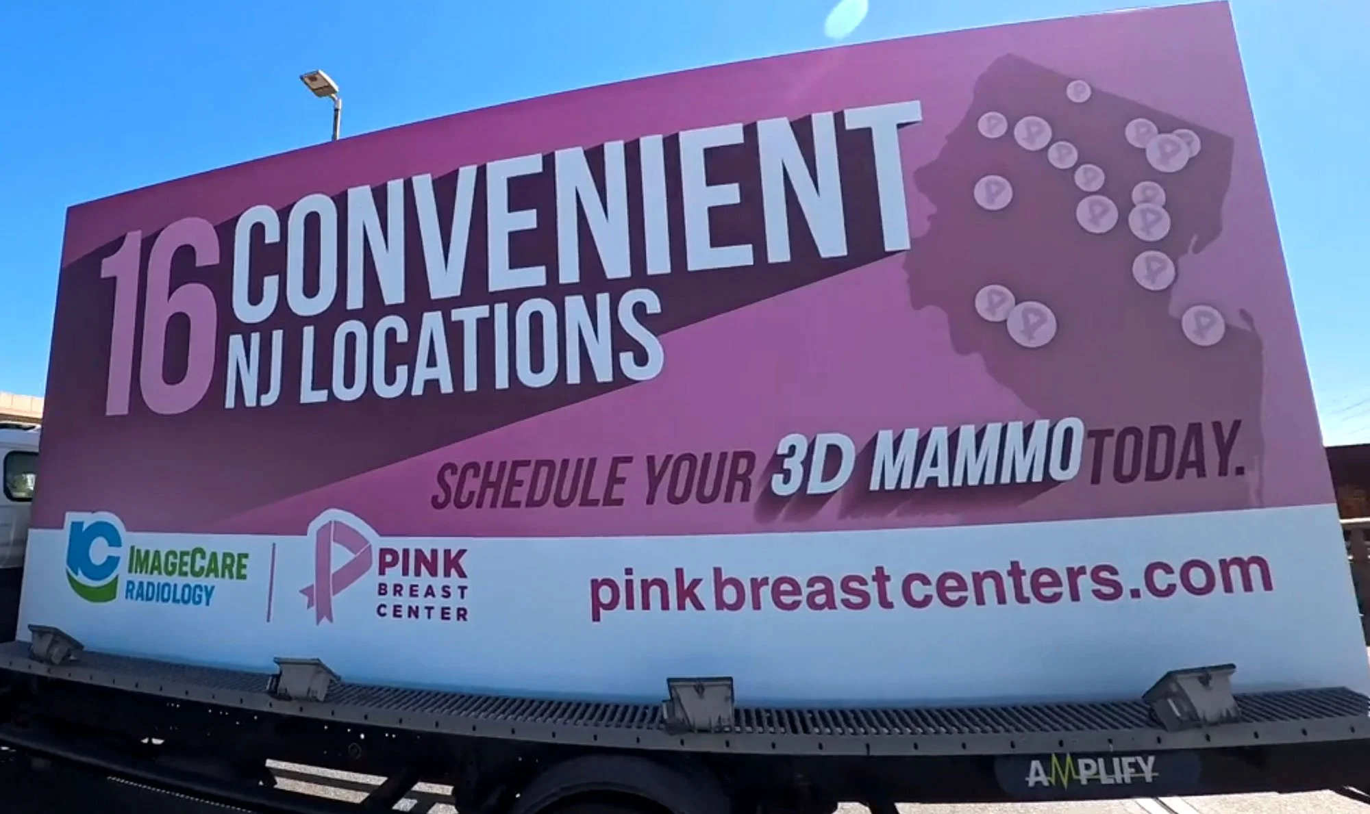 Advertisement billboard for pink breast centers promoting 16 NJ locations, scheduling 3D mammograms, featuring a map of New Jersey with pink dots, logos of ImageCare Radiology and Pink Breast Center, and website pinkbreastcenters.com.
