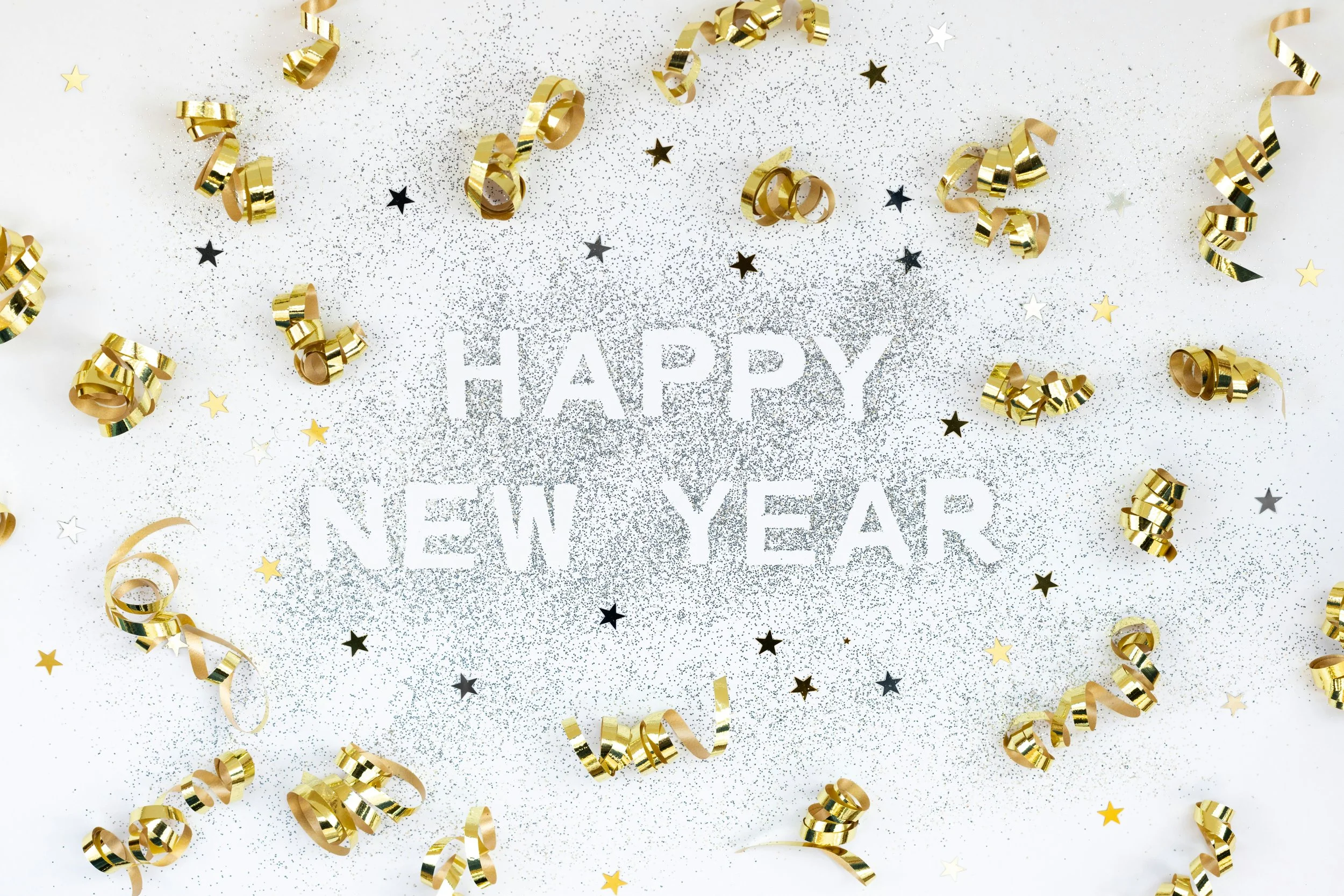 An image of text saying happy new year with ribbons.