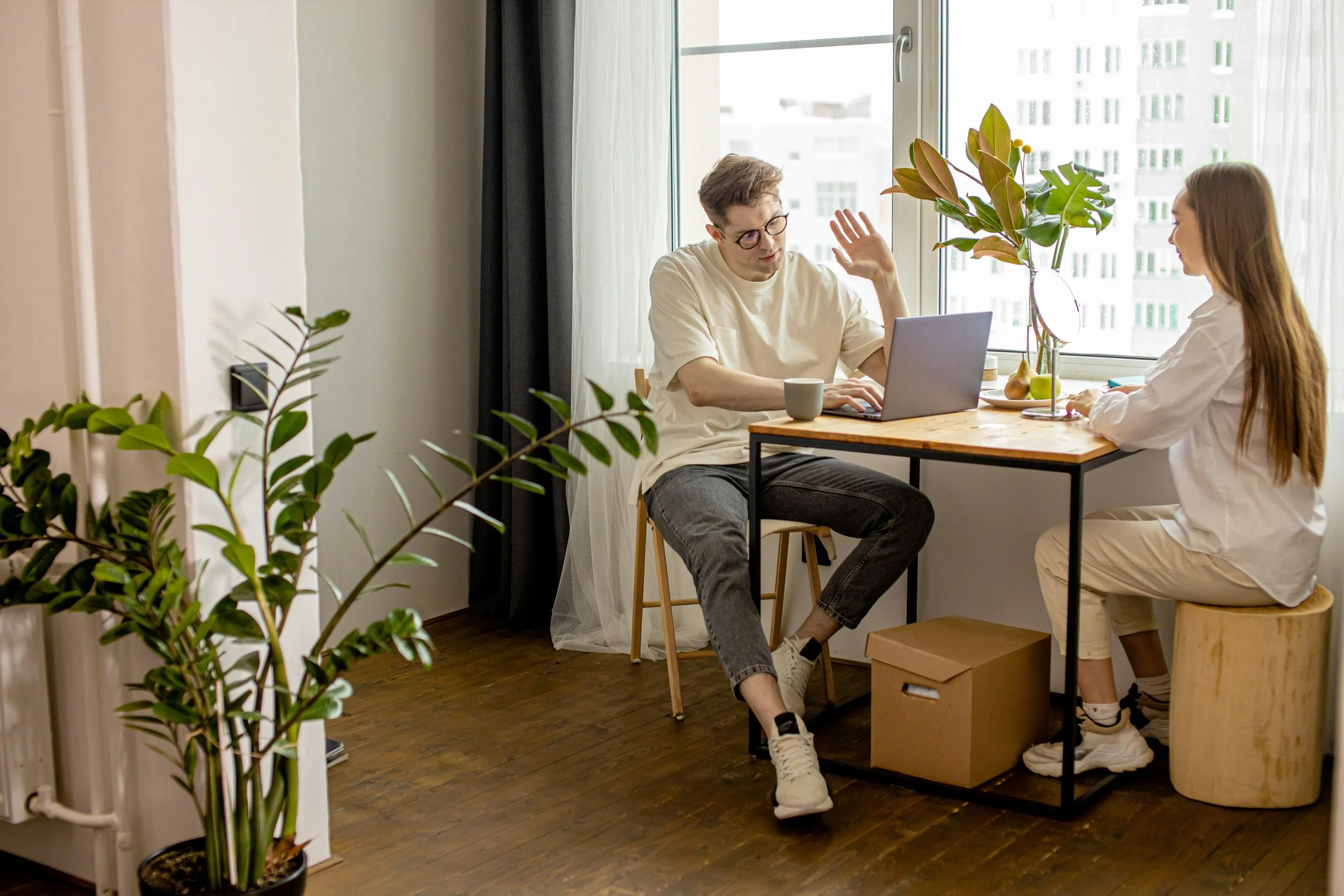 A photograph of two people discussing something at a table to illustrate how being regulated keeps us in the present moment when connecting to other people.