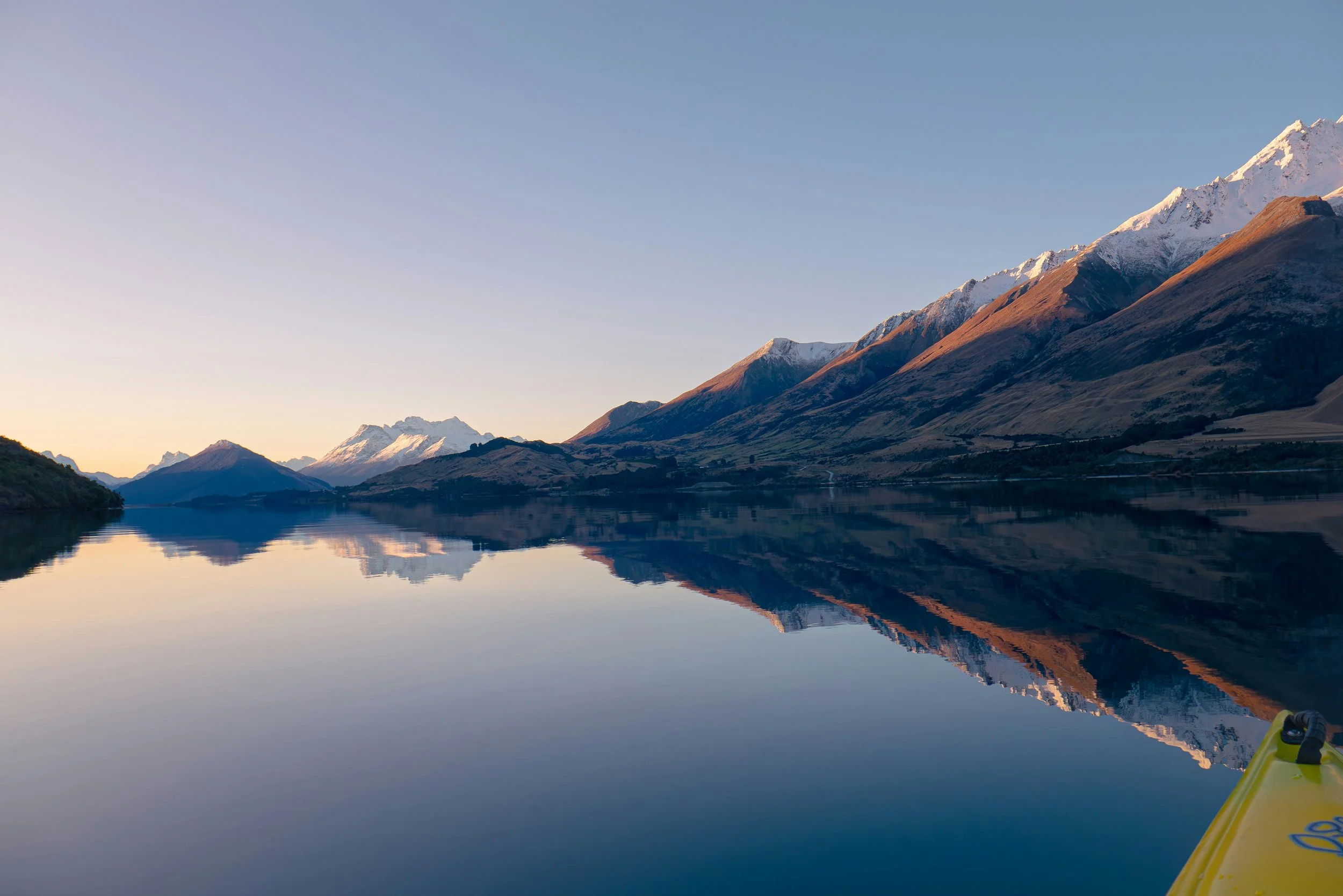 An image of a calm lake with mountains around it to demonstrate staying regulated.