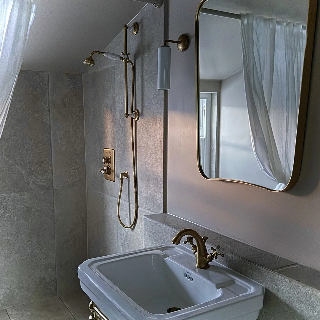 An angle of this bijou shower room, where natural materials and soft, earthy hues come together to create a space that is both feminine and minimal.
Whether you are planning a simple shower room makeover or have ambitious renovations plans, we'd lov