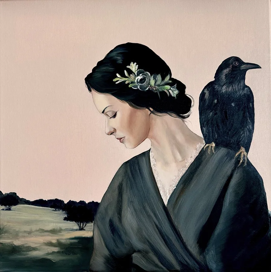 Dark-haired woman in a black dress with a crow perched on her shoulder, set against a pale rural landscape.