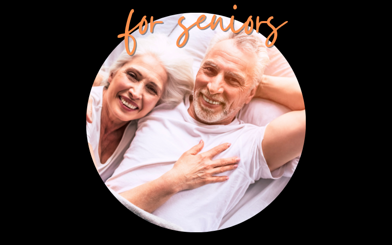Grandmother, grandfather, and young girl reading a colorful picture book together, smiling happily.