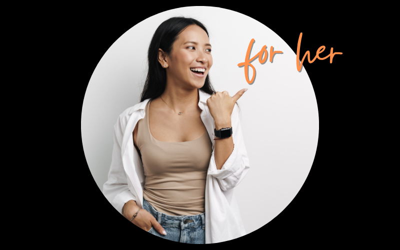 Young woman with long dark hair smiling and pointing to her left, wearing a beige top, white shirt, jeans, and a smartwatch, standing against a white background.