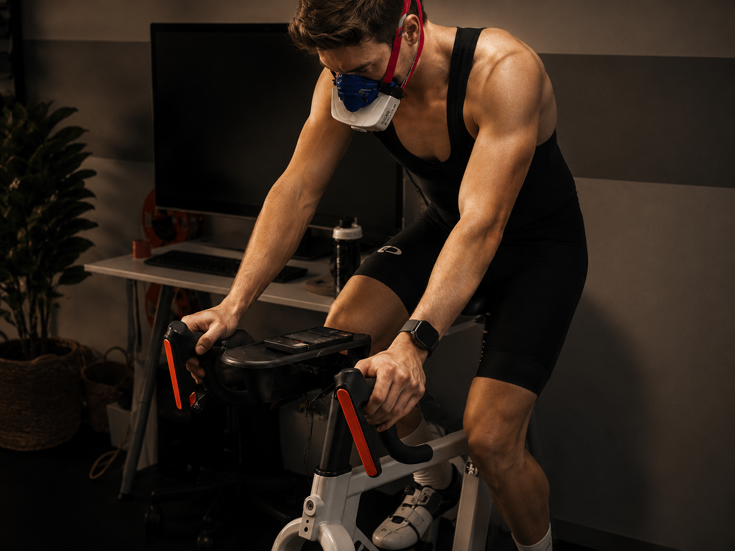 A man wearing a face mask with a respirator is riding a stationary exercise bike indoors.